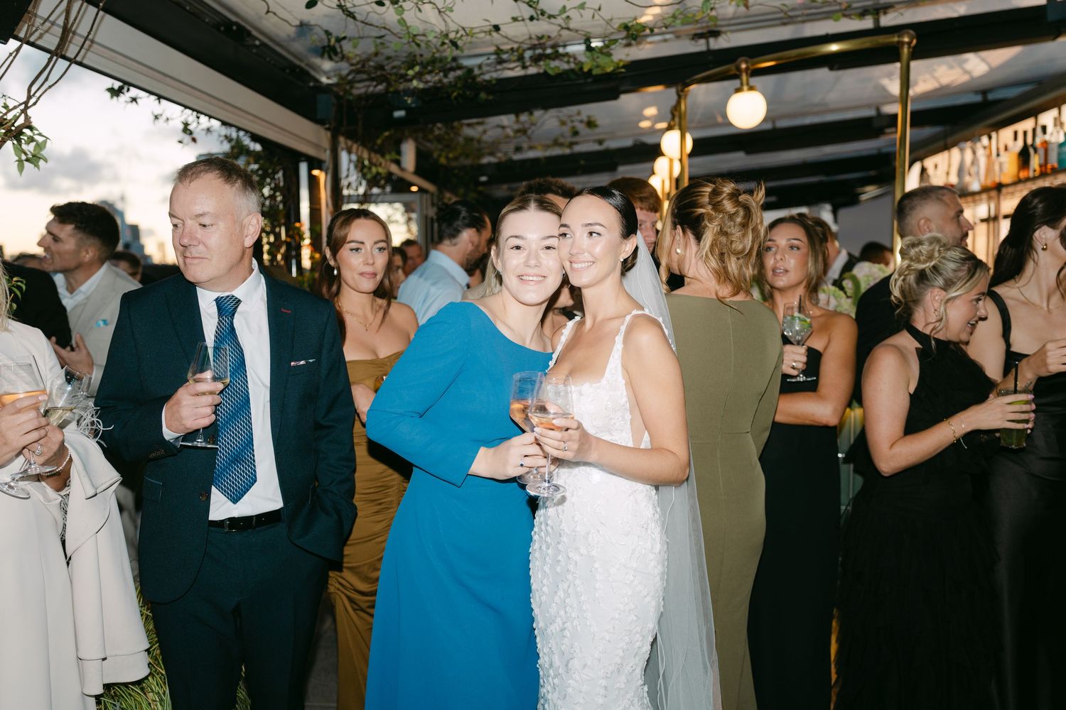 Wedding reception guests dancing and socializing in a decorated indoor venue.