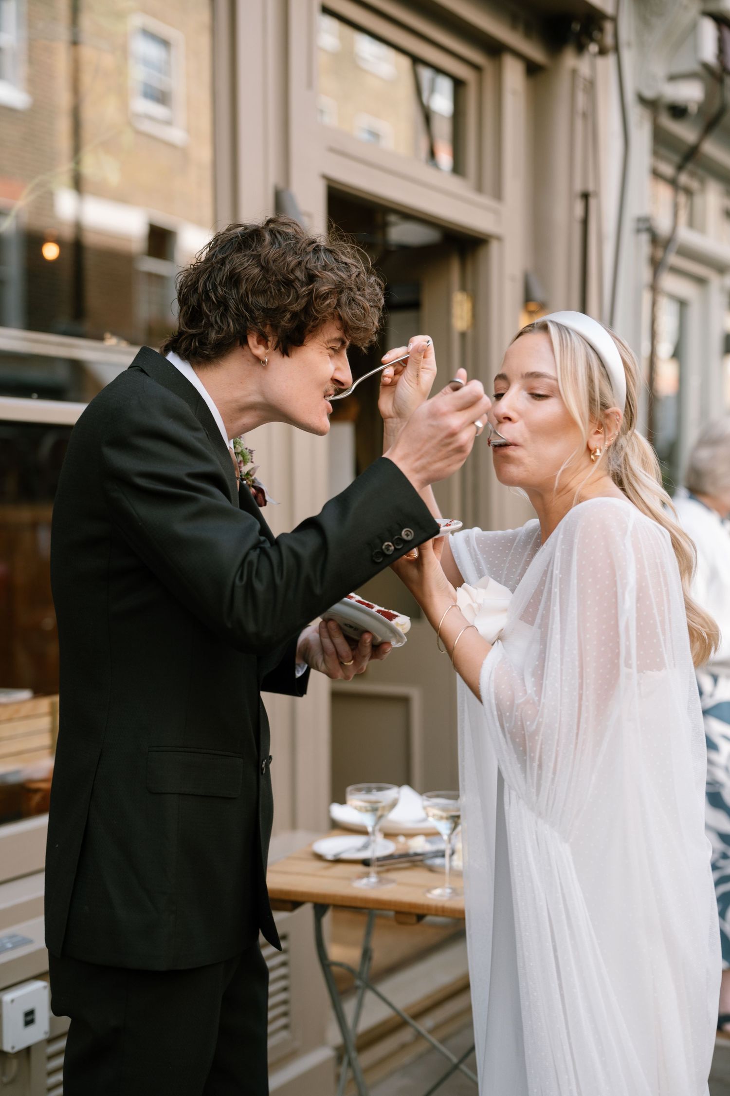 Newlyweds playfully feed each other wedding cake in a sequence of romantic photos.