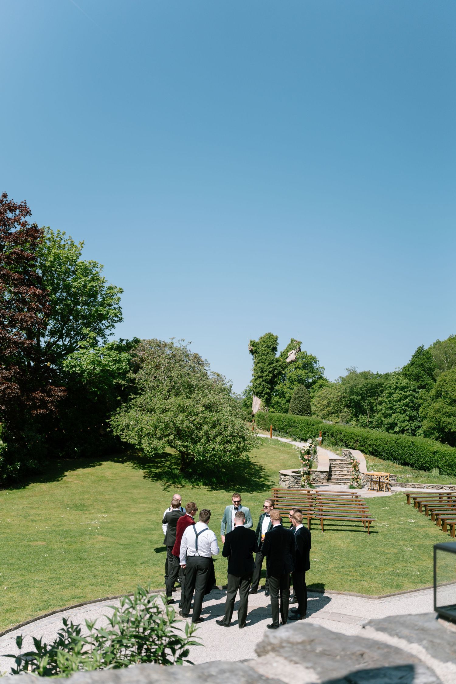 Outdoor venue with green lawn and amphitheater-style seating under blue sky.