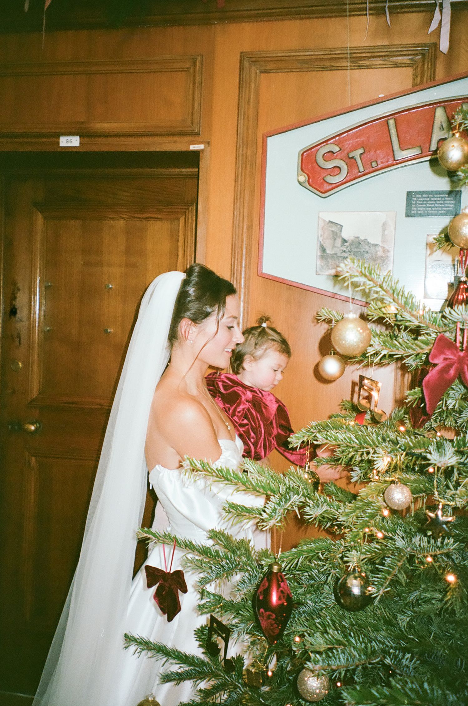 A sequence of photos showing someone in a white dress decorating a Christmas tree with ornaments and lights.