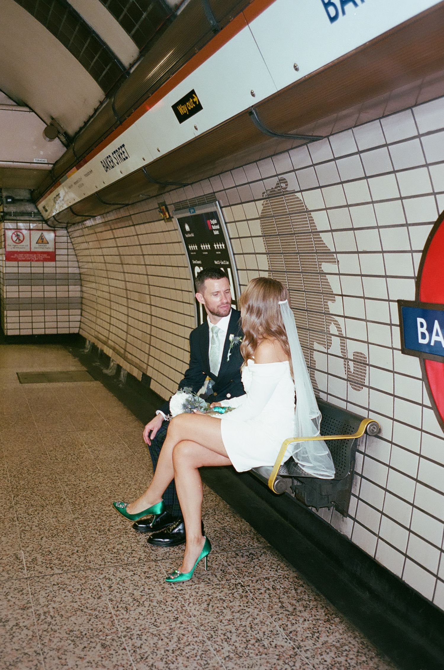 A sequence of photos showing someone in green shoes reaching down to retrieve something from subway train tracks.