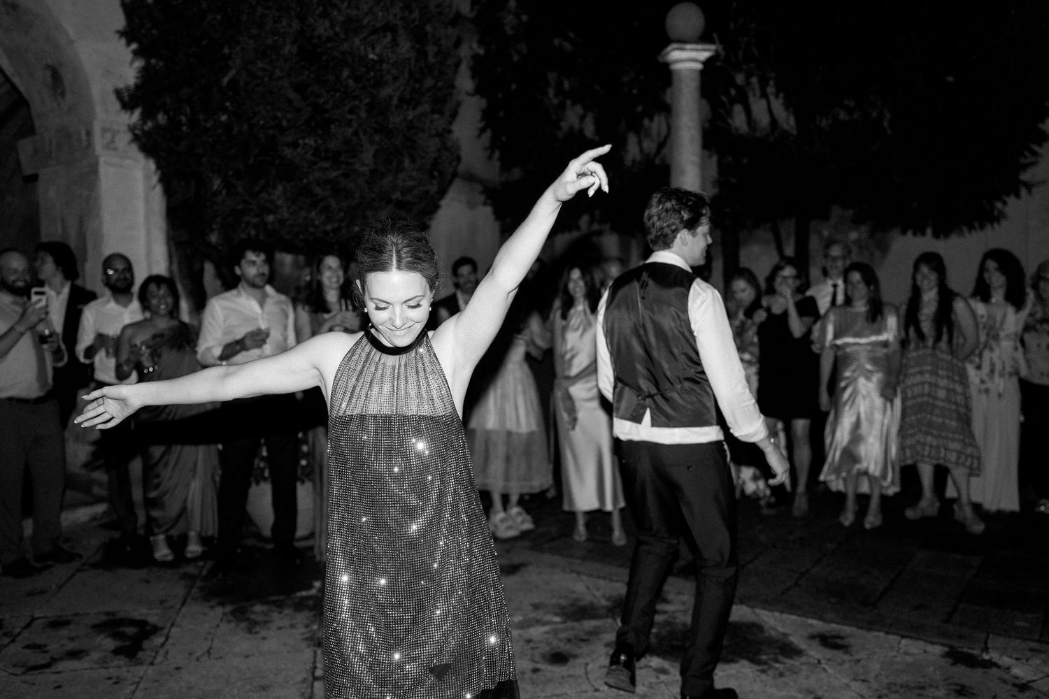 People dancing and celebrating at an outdoor nighttime gathering.