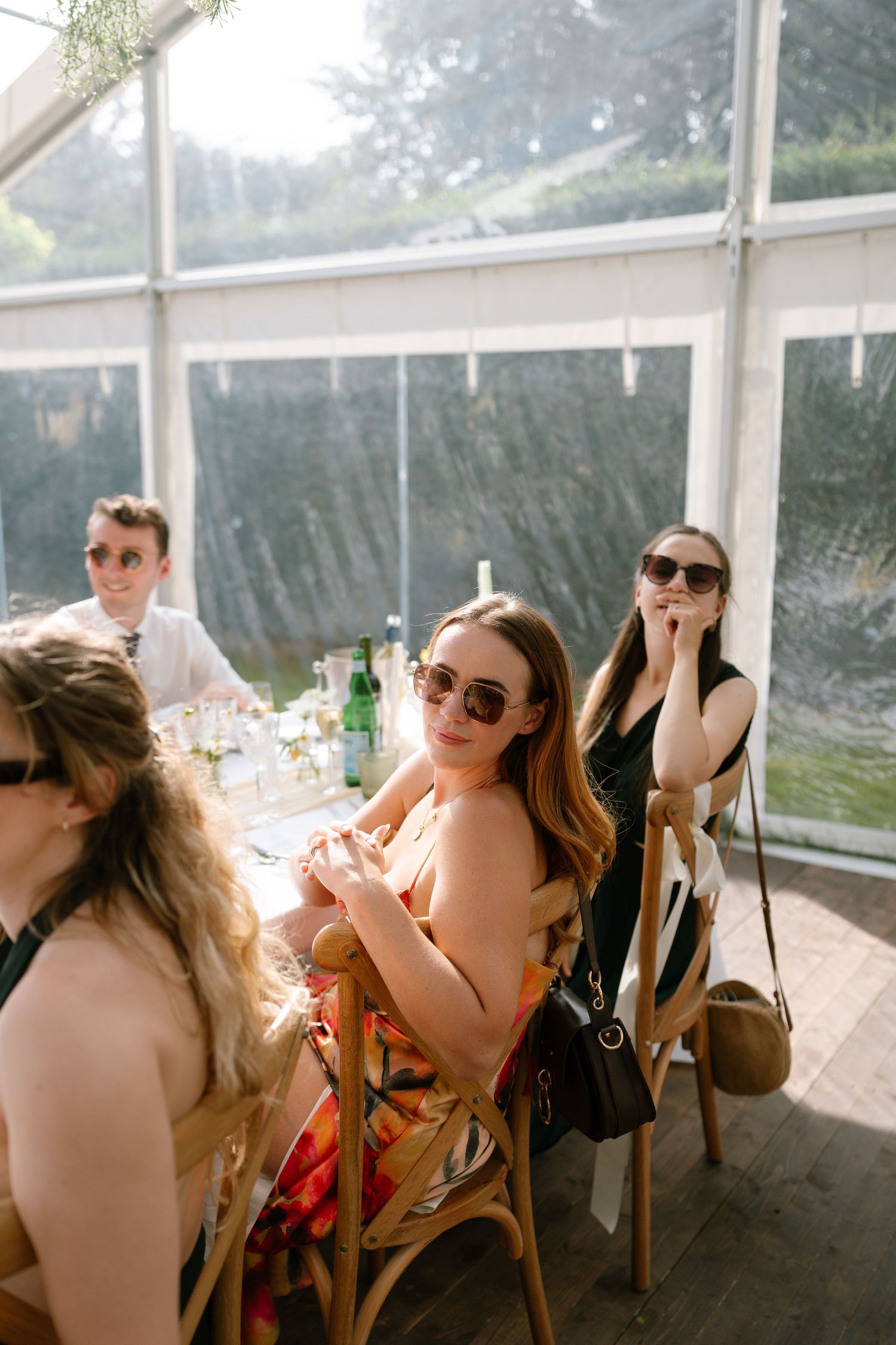 Wedding guests laughing and socializing during an outdoor tent reception.