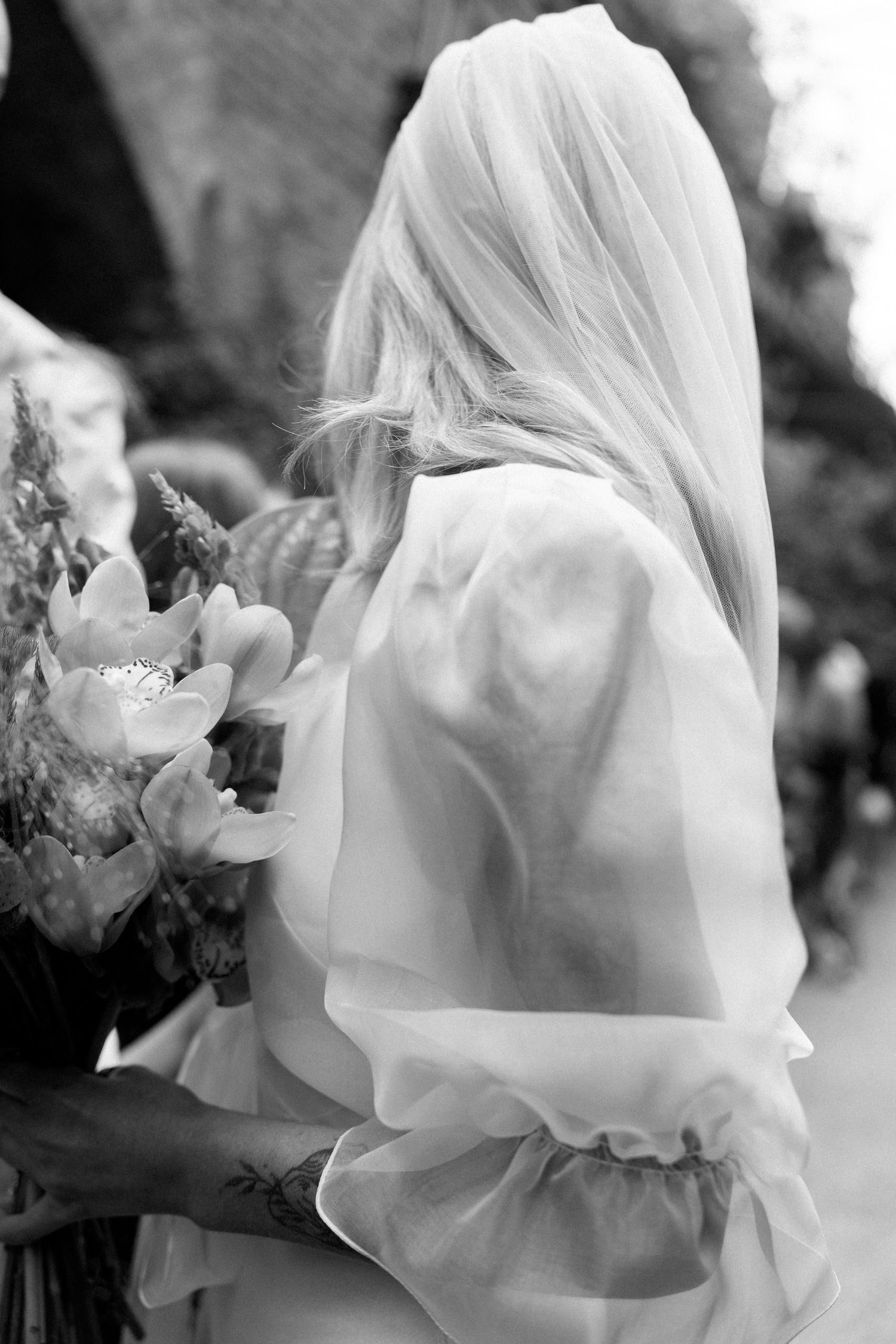 Ethereal black and white photo of flowing white fabric and flowers.