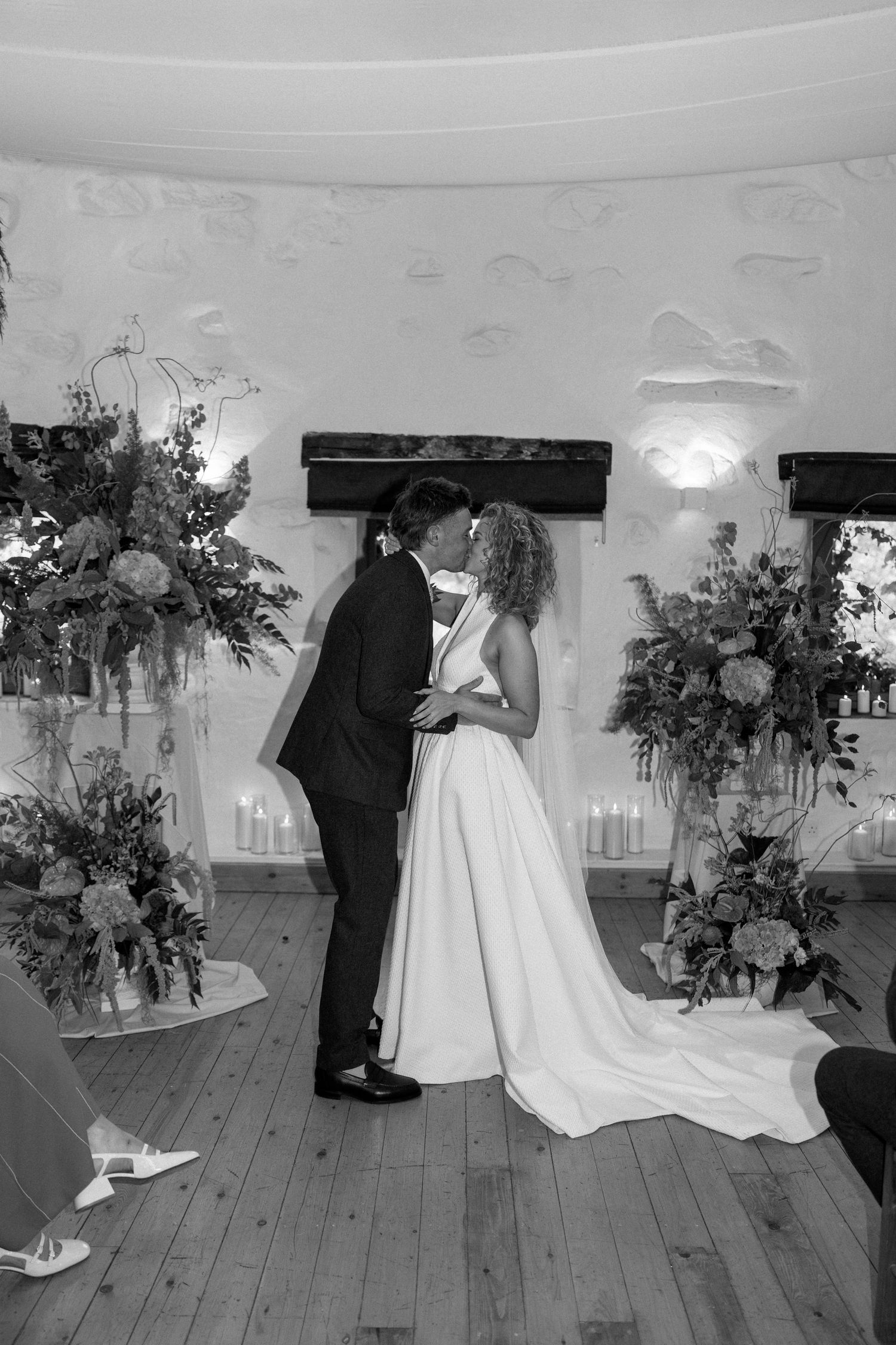 Wedding ceremony photos in a rustic indoor venue with floral decorations.