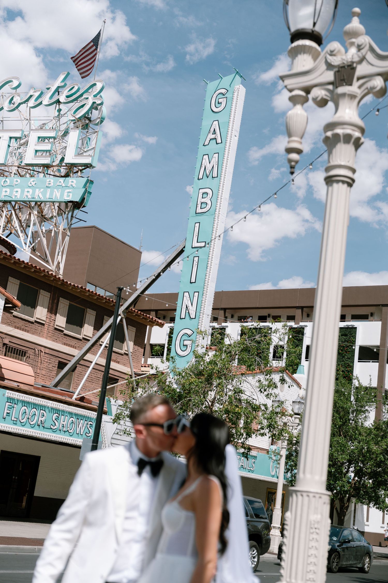Vintage-style street lamps and signs line an urban street under blue skies.