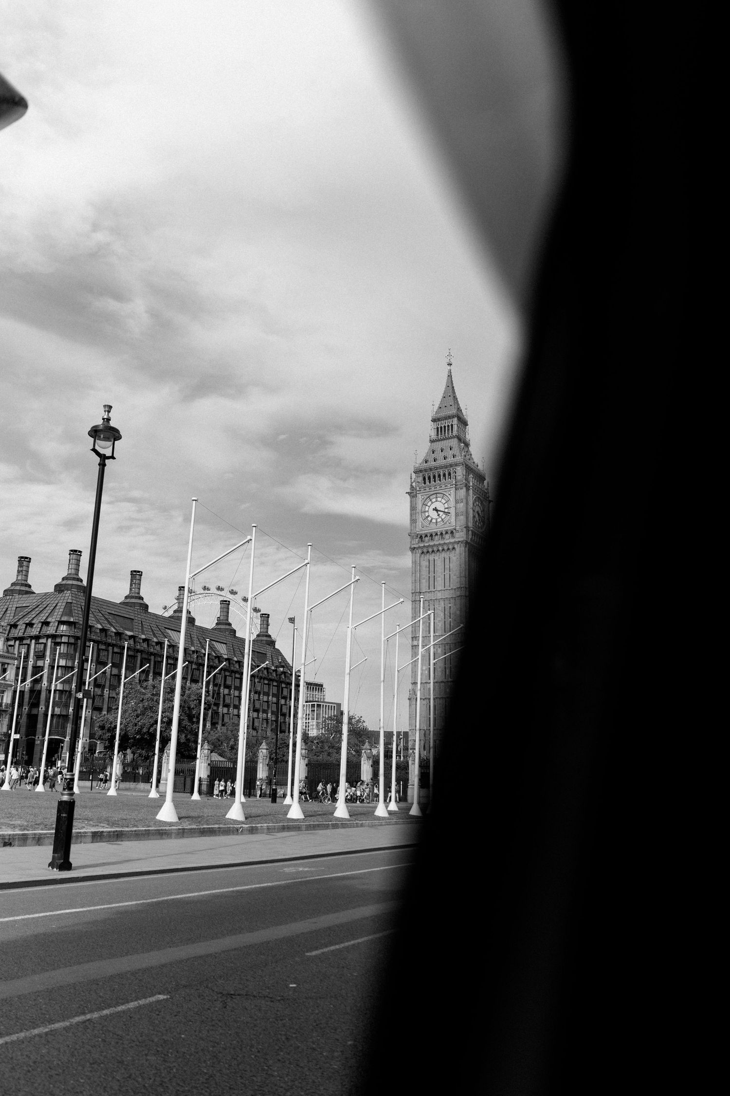 Black and white view of Big Ben and Westminster from car window on cloudy day.