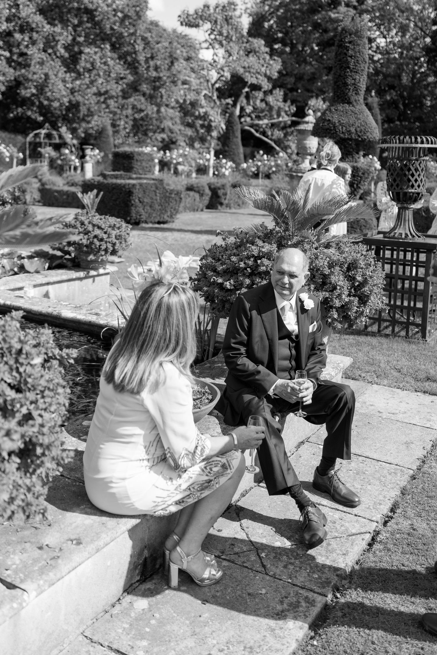 Guests share a relaxed moment on garden steps during an outdoor celebration.