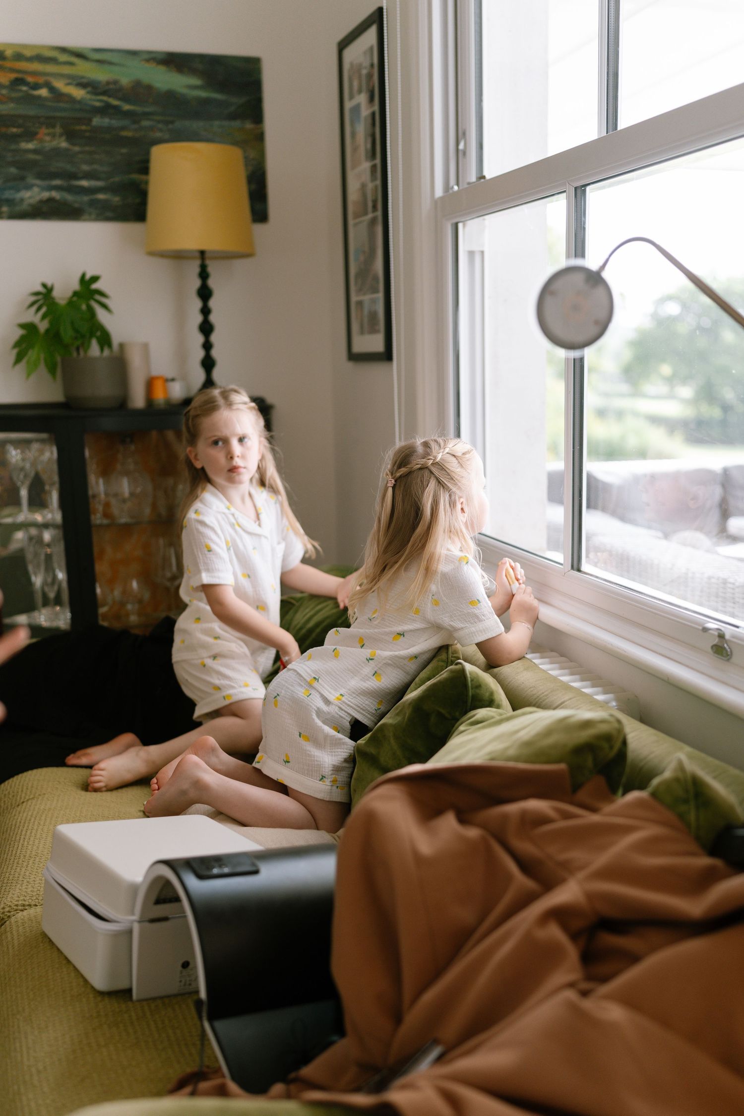 Casual moment captured in living room with yellow lamp and green couch.