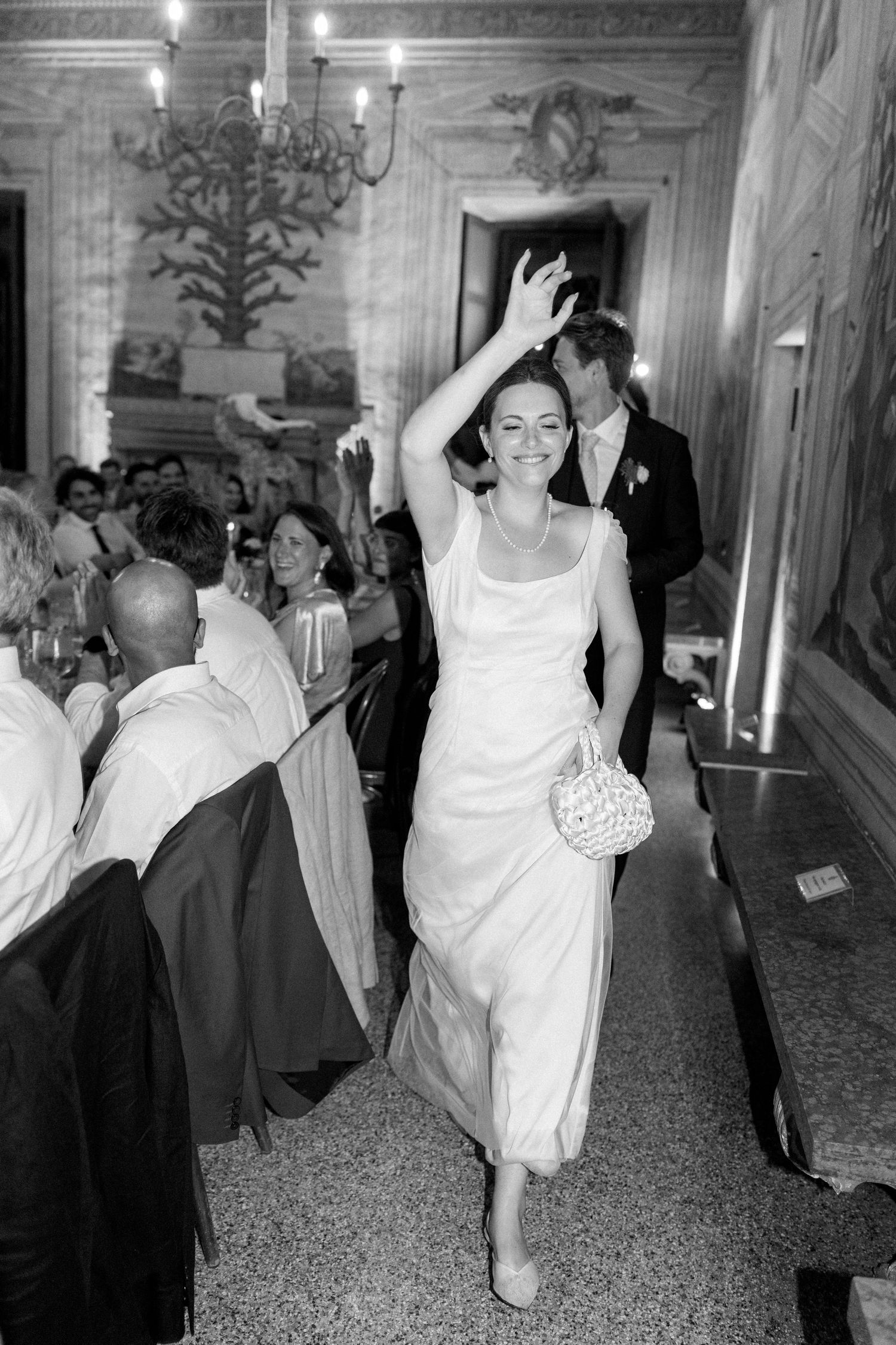Wedding guests dancing and celebrating in formal attire at an elegant ballroom reception.