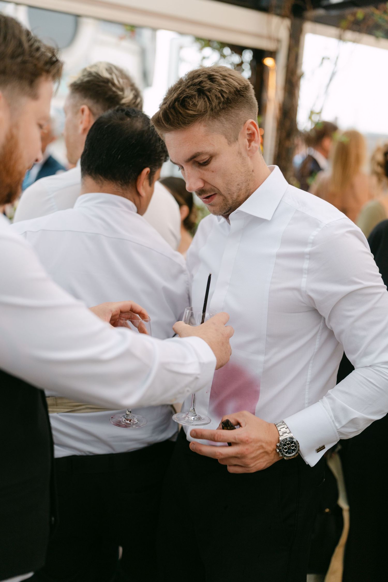 Groomsmen in white shirts adjusting their formal attire before the ceremony.