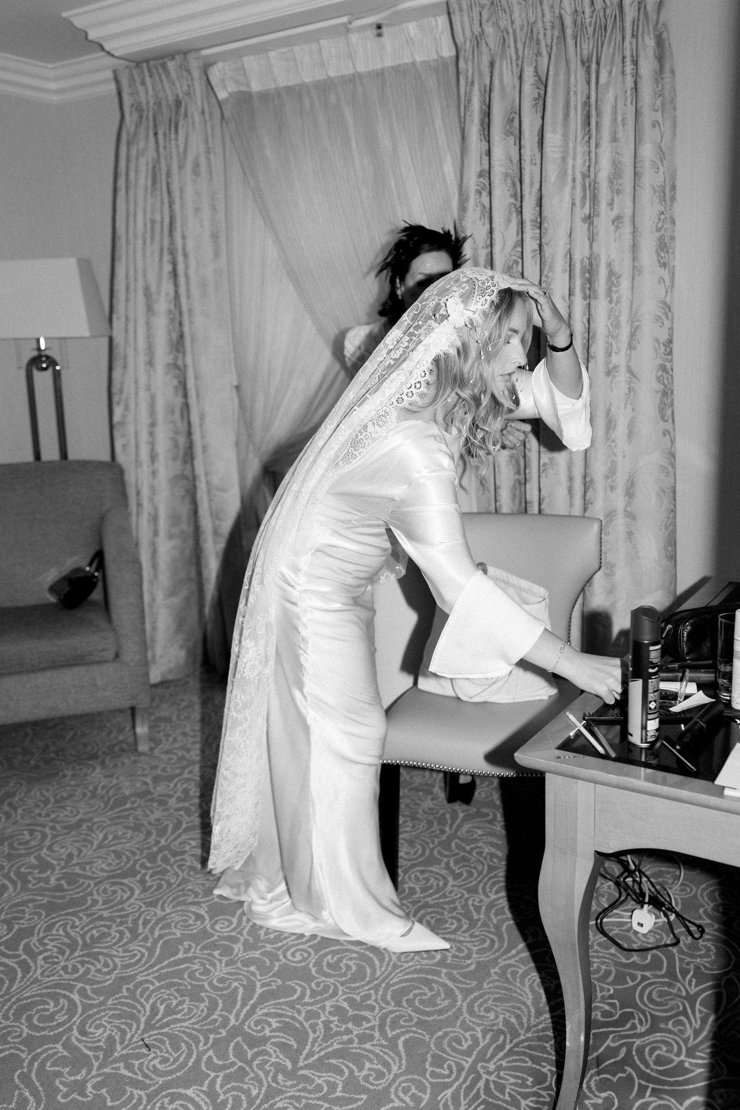 Black and white sequence of someone in a white dress using a vintage telephone in an elegant room.
