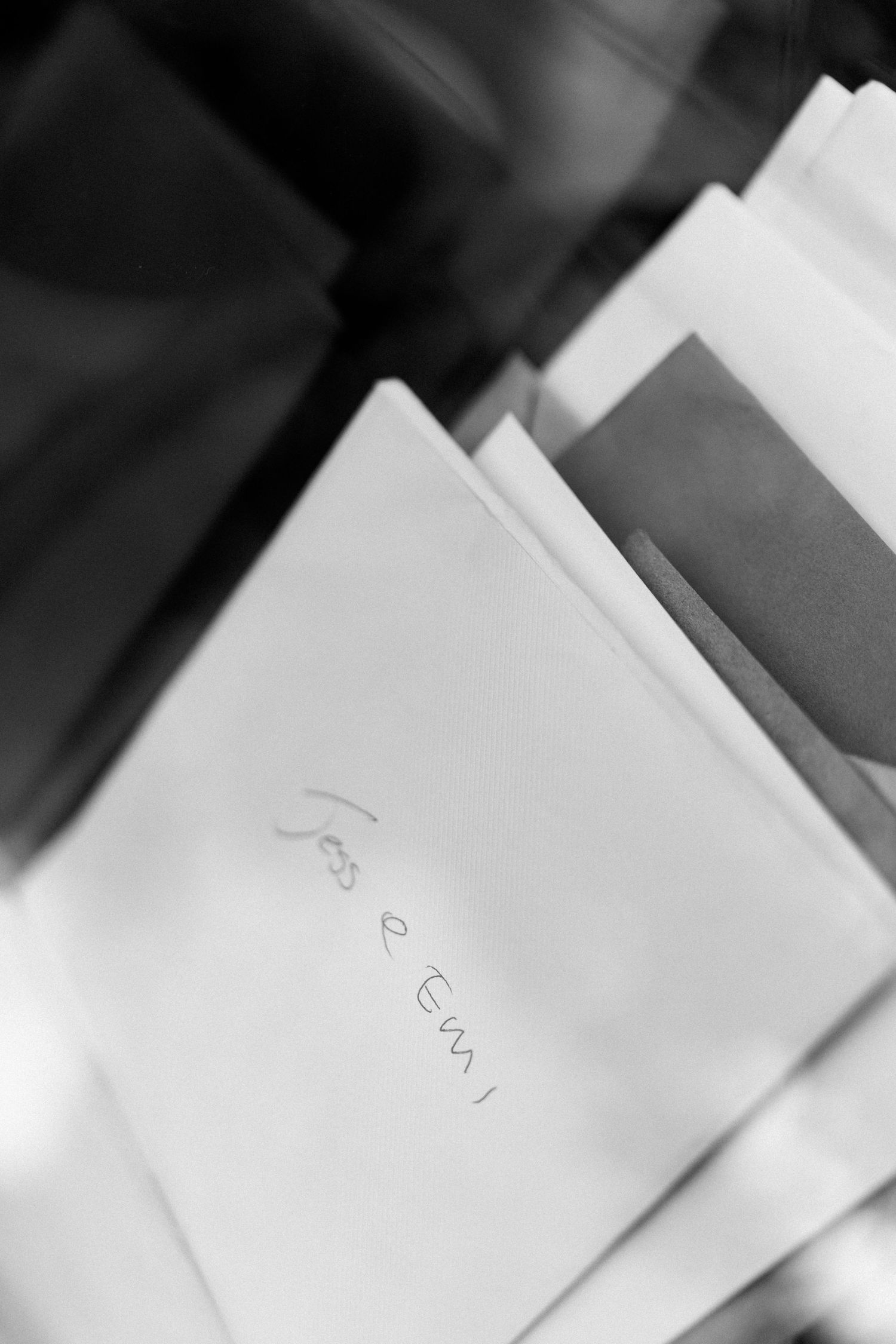 Close-up view of white paper sheets or cards with blurred text in a monochromatic style.