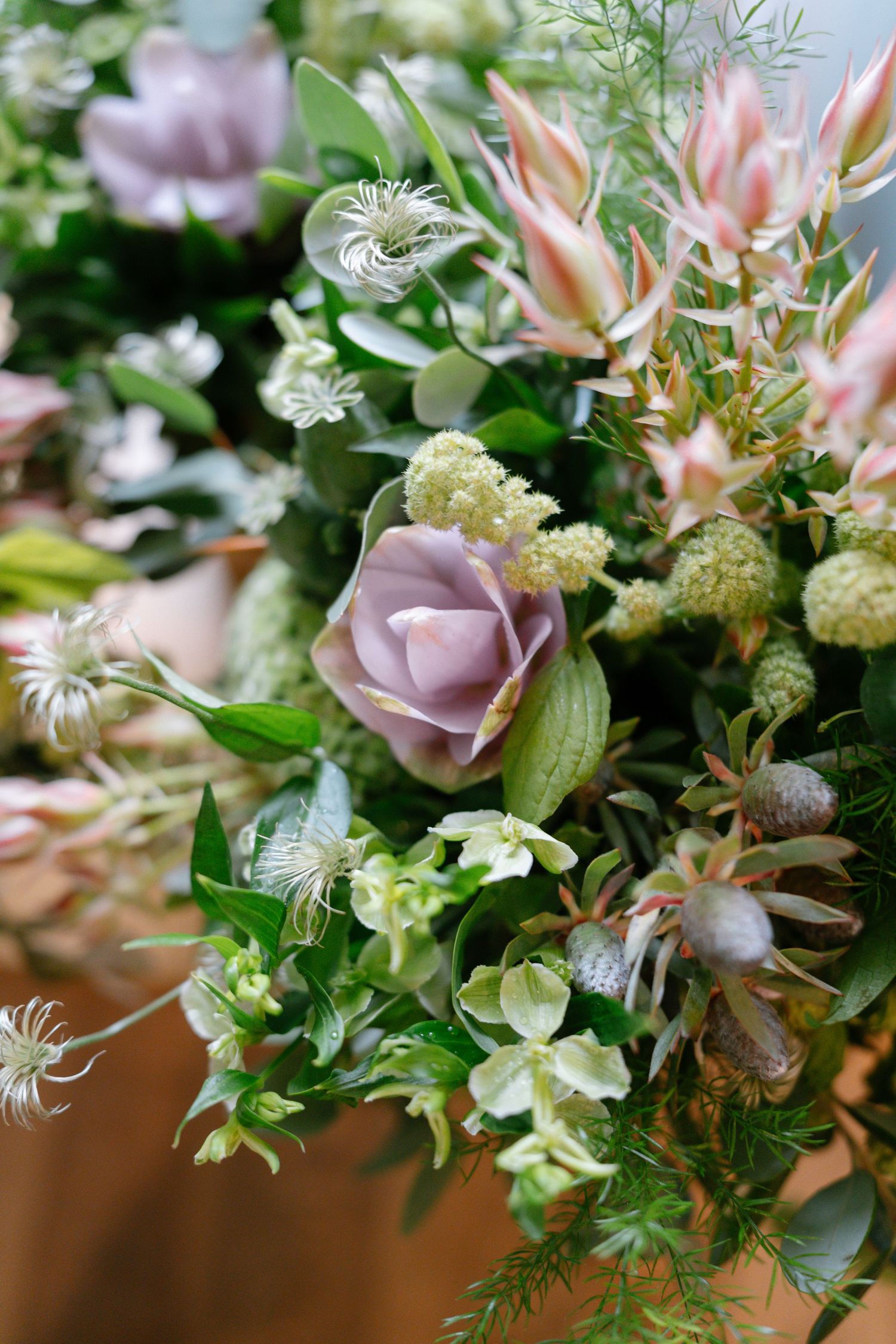 Delicate floral arrangement with pink and white blooms mixed with fresh greenery and foliage.