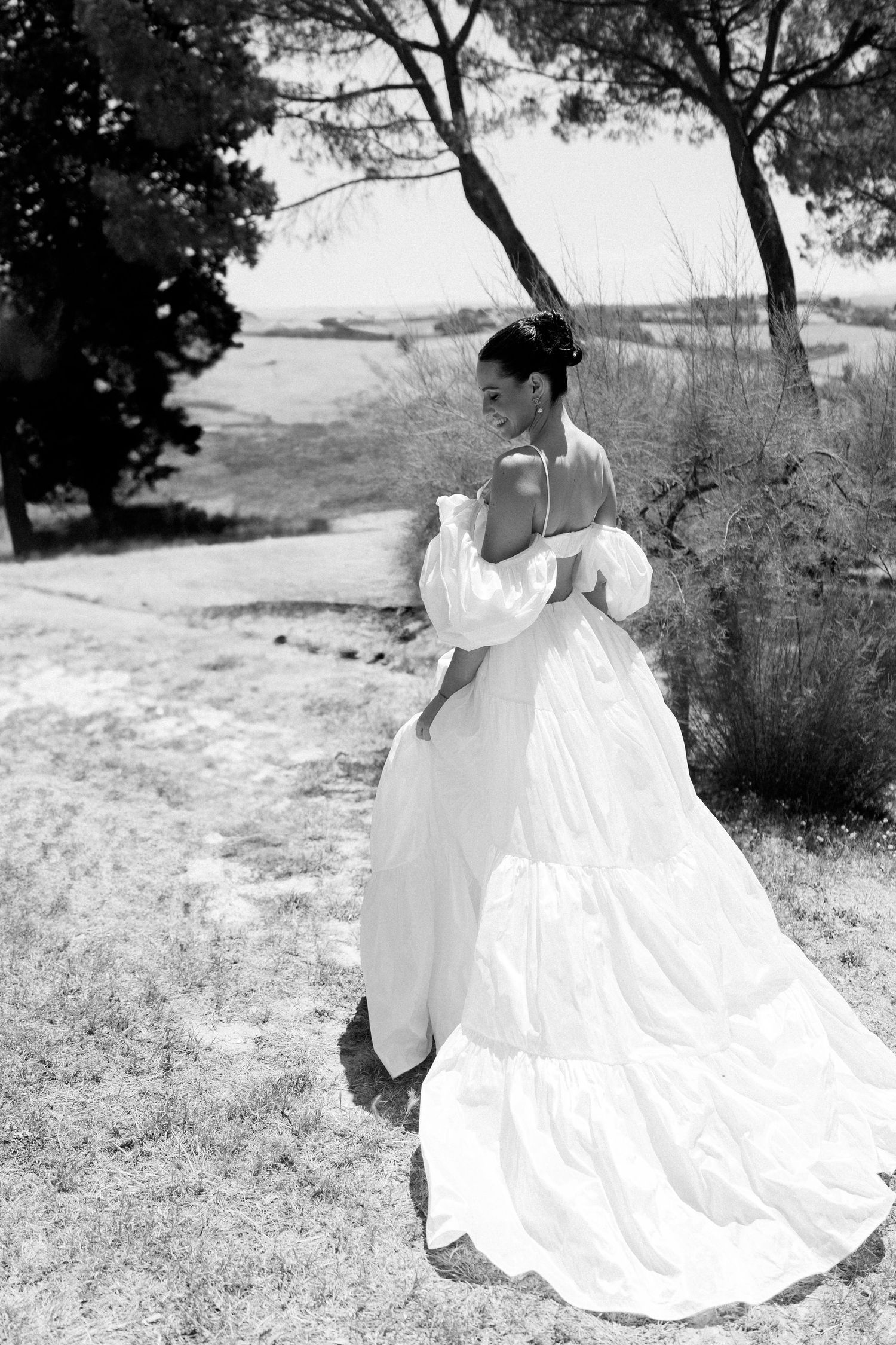 A series of black and white photos showing a flowing white wedding dress twirling in an outdoor natural setting.
