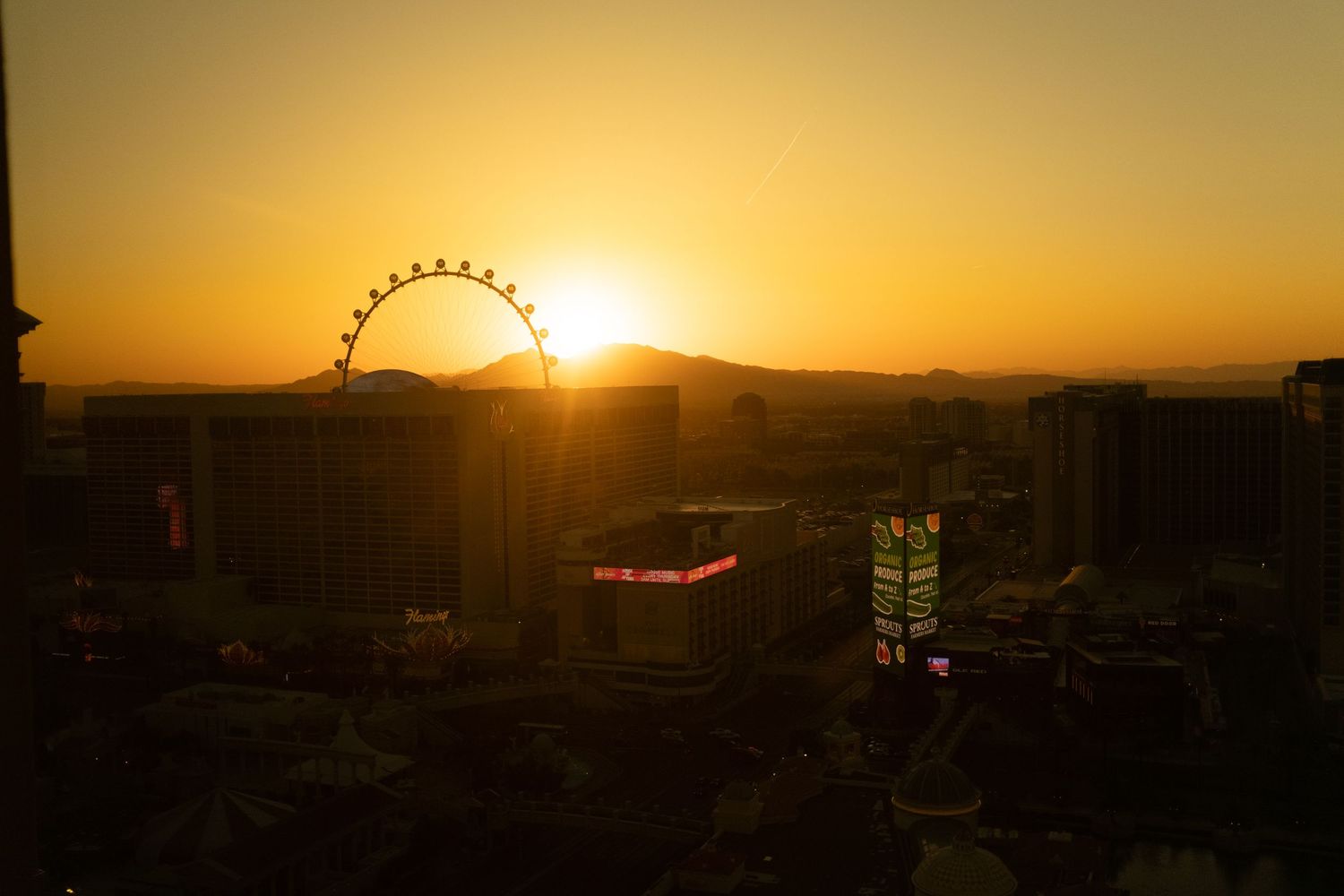 Golden sunset over Las Vegas with the High Roller observation wheel silhouetted against the sky.