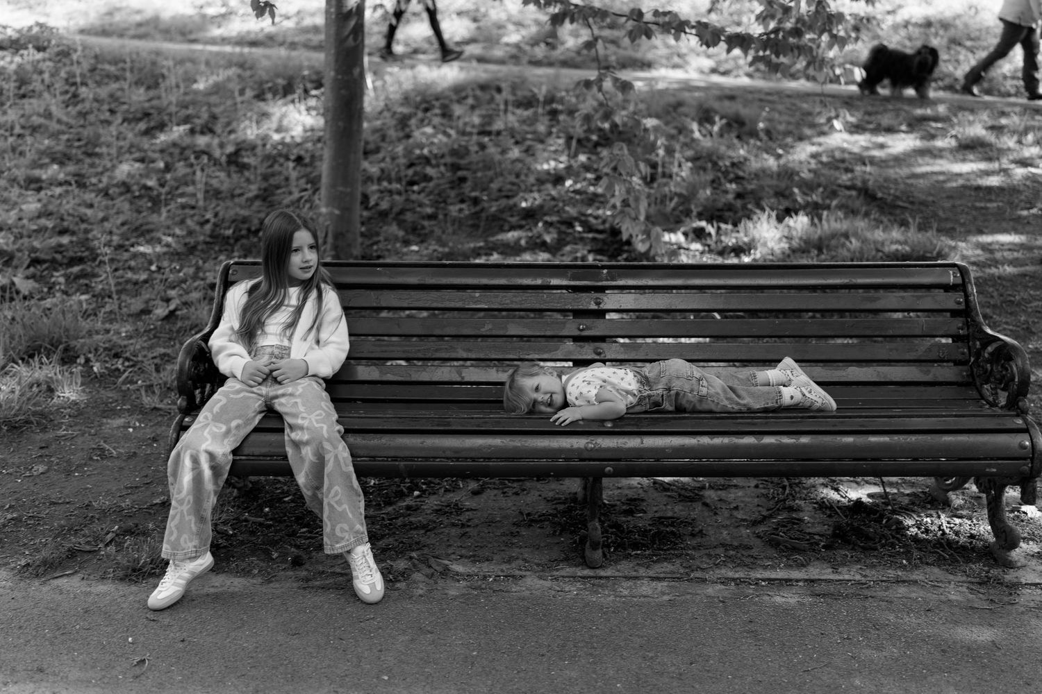 Black and white sequence of people sitting on park benches overlooking a scenic view.
