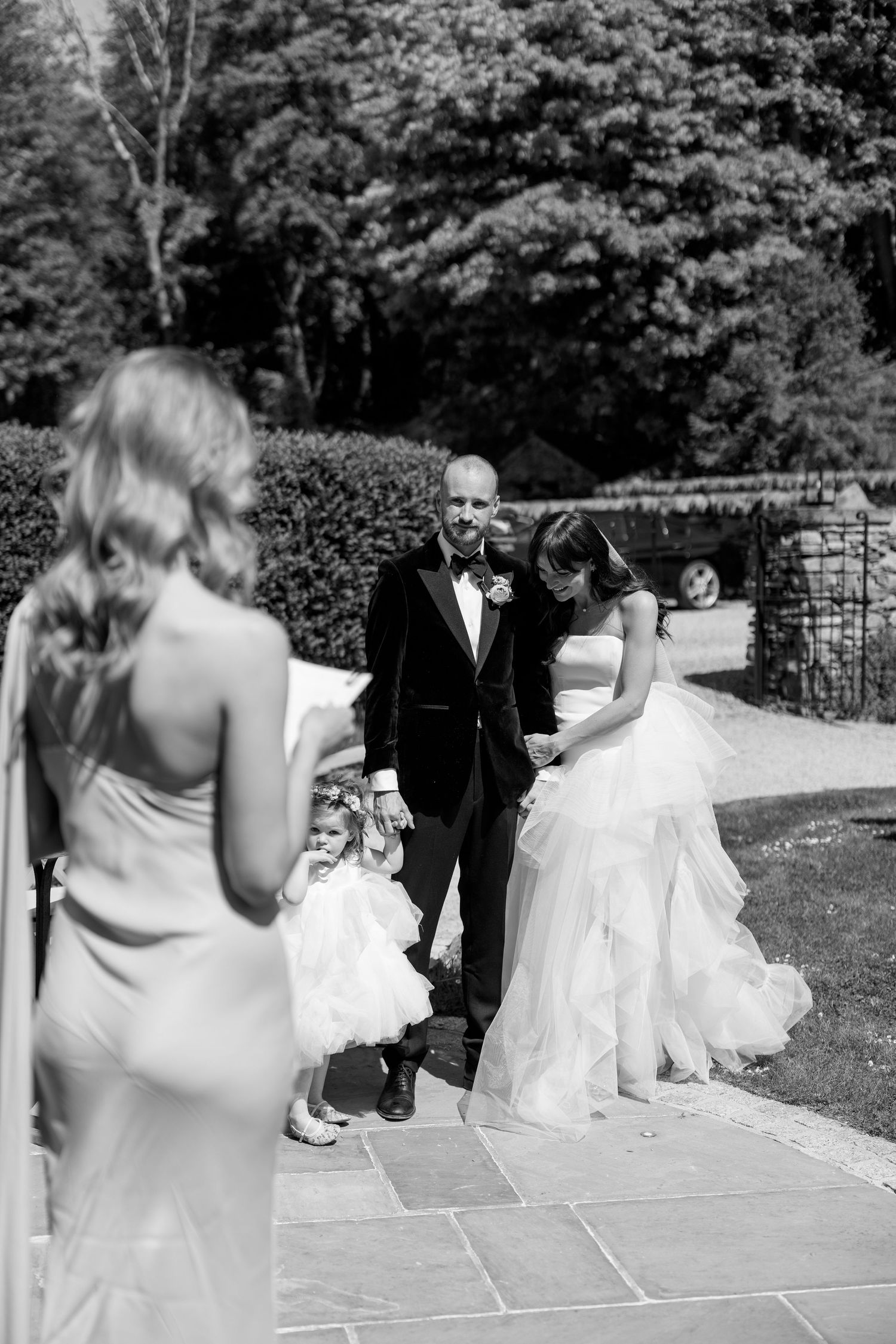 Black and white sequence of wedding party members dancing on a stone patio.