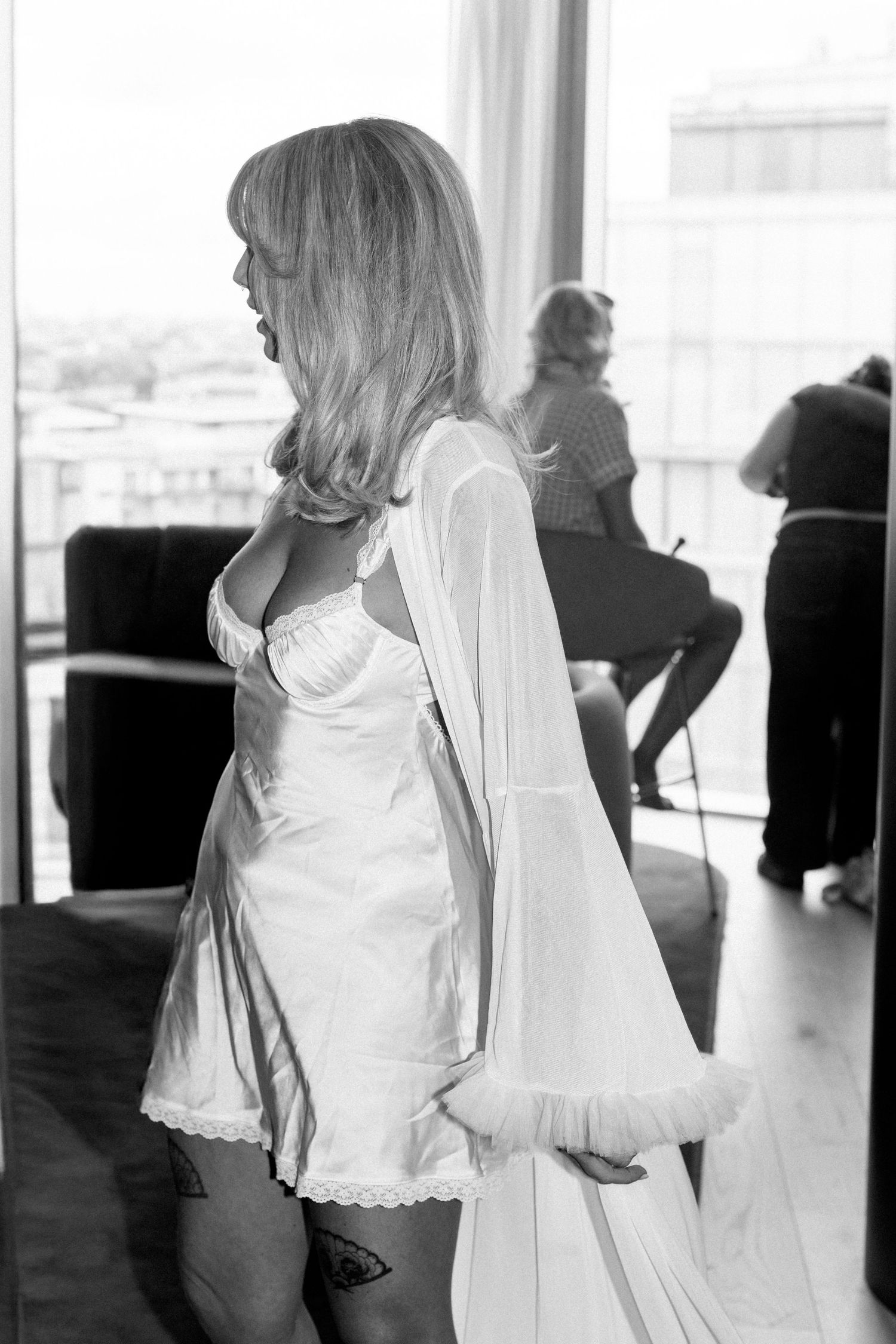 Black and white images of wedding preparation with flowing white fabrics and movement.