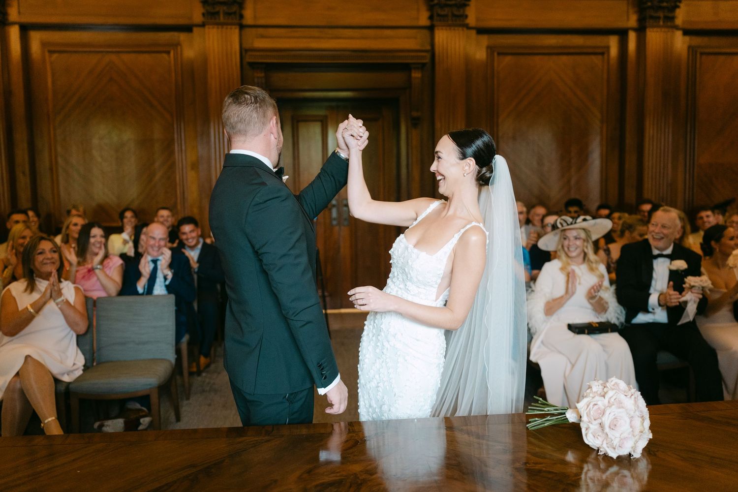A tender moment between newlyweds during their first dance in an elegant venue.