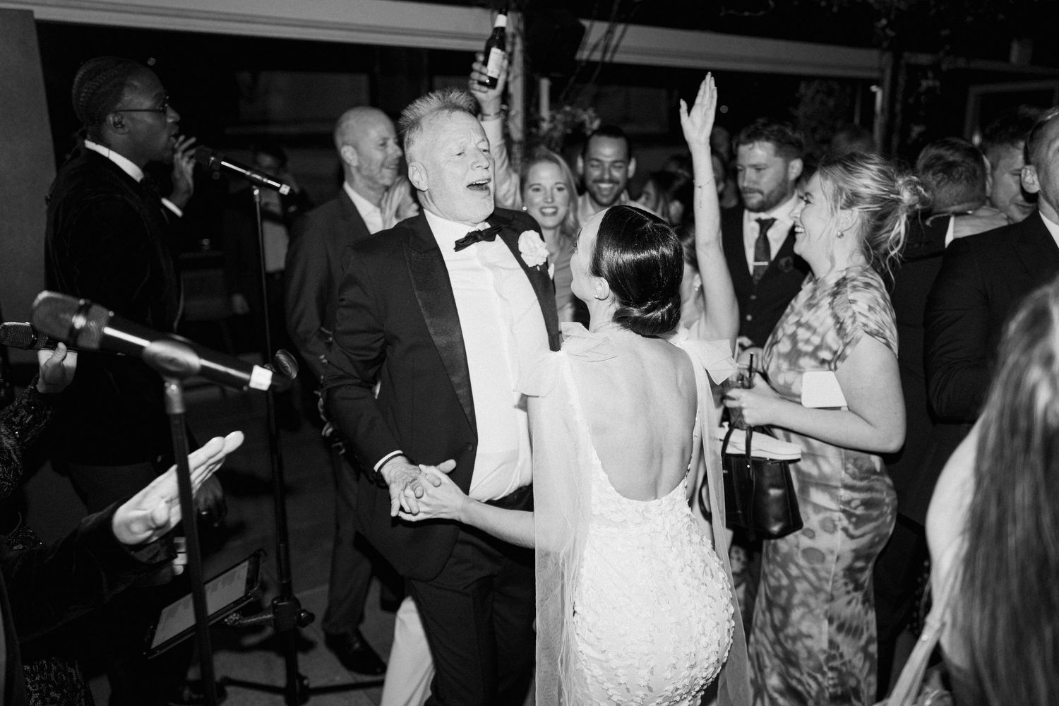 Crowded dance floor with wedding guests celebrating in formal attire.