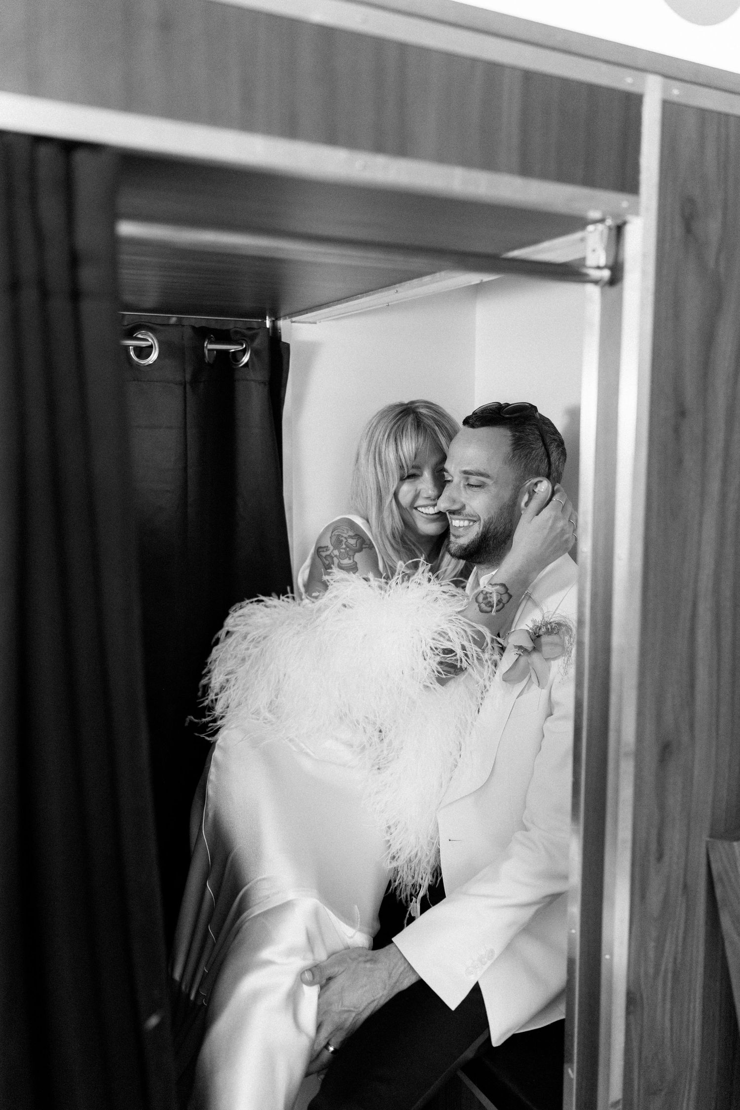 Wedding couple embraces in a romantic moment against a mirrored background.