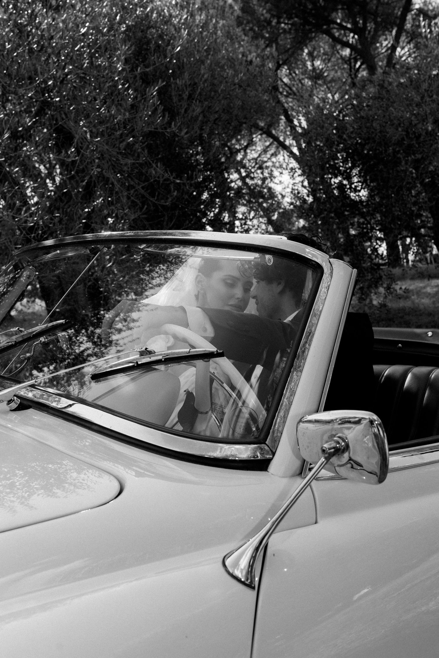 Series of black and white shots showing a classic convertible car at a wedding.