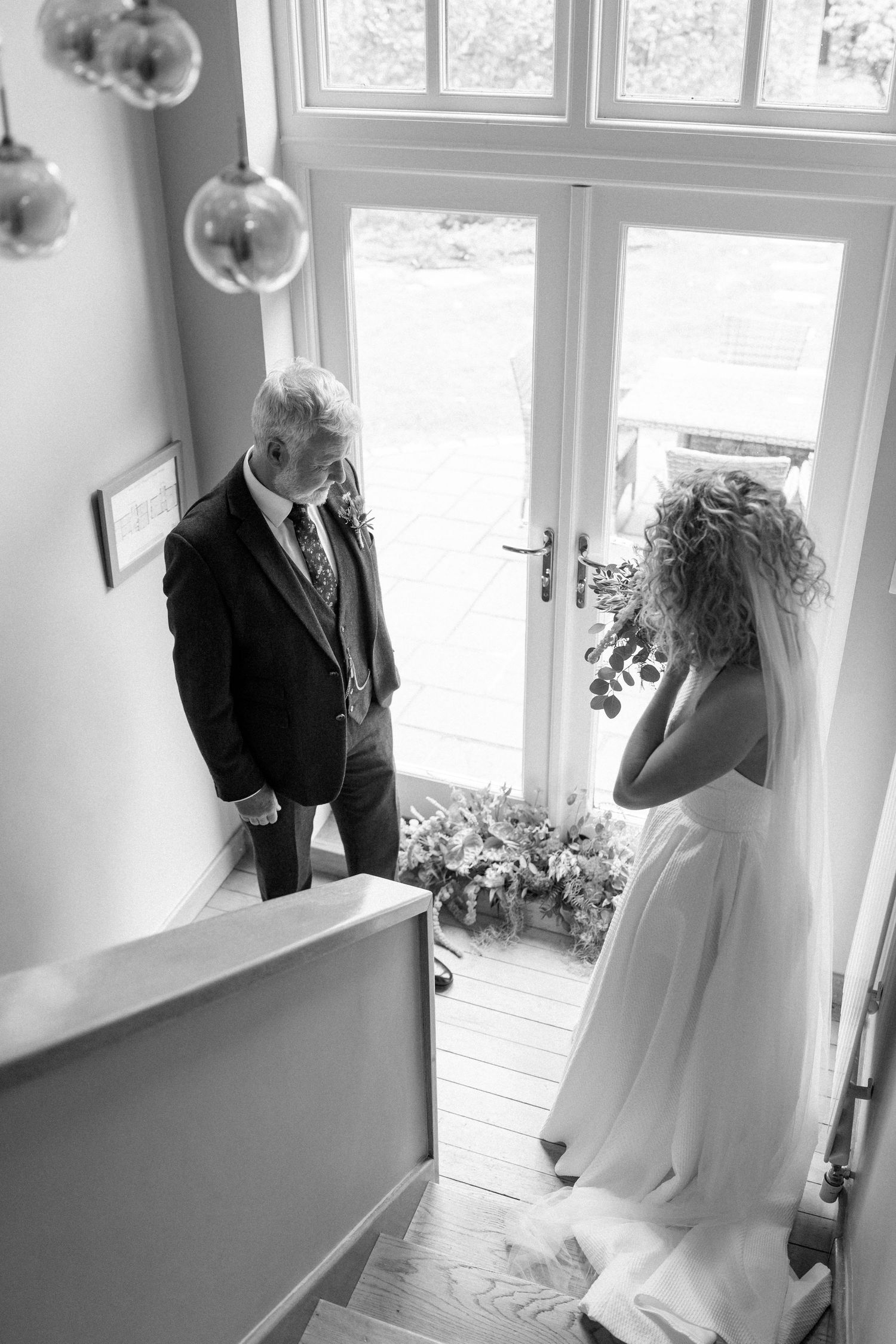 Black and white wedding preparation photos in bright interior space.