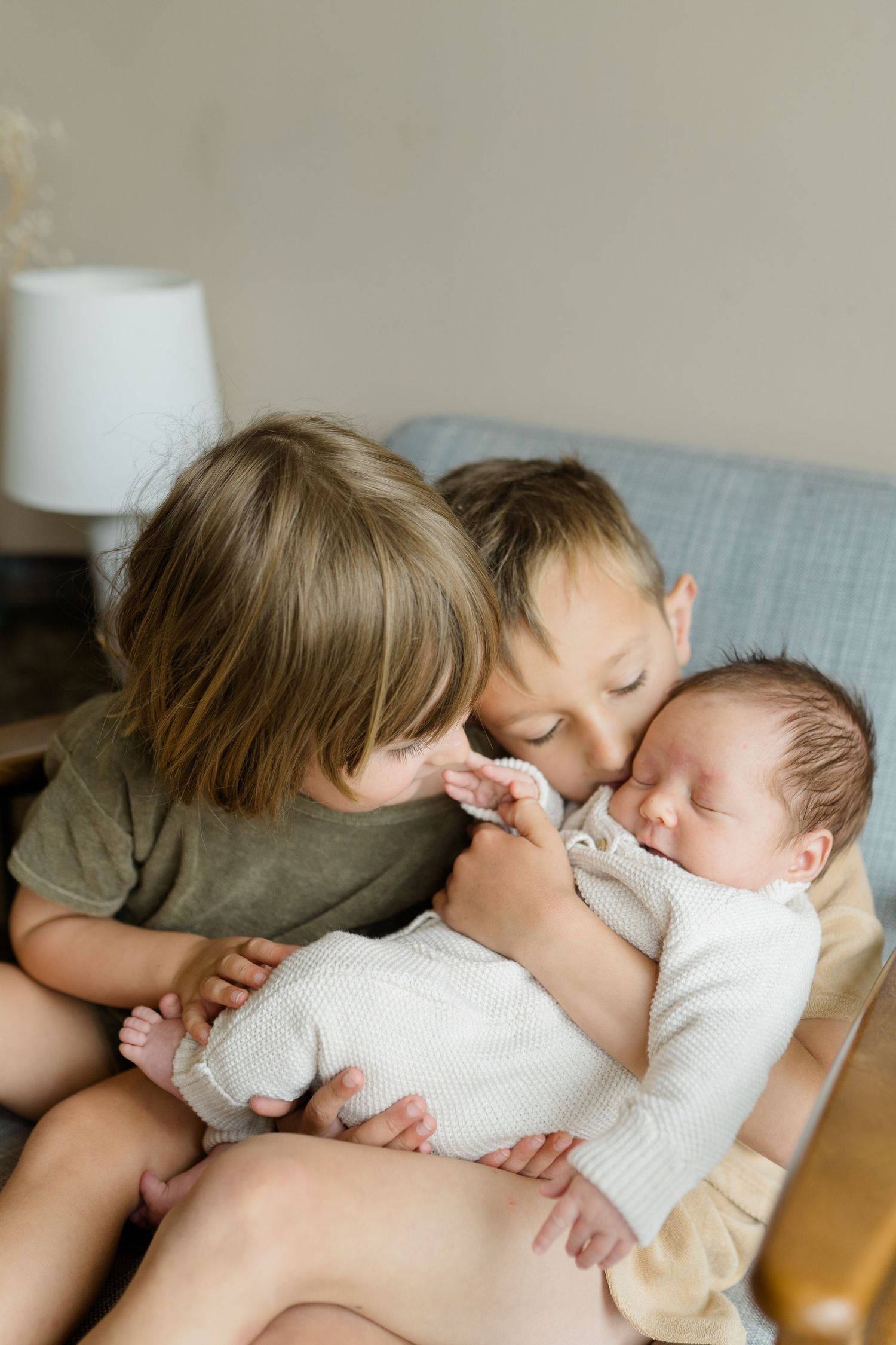 A series of tender moments captured on a couch showing peaceful bonding with a sleeping infant.