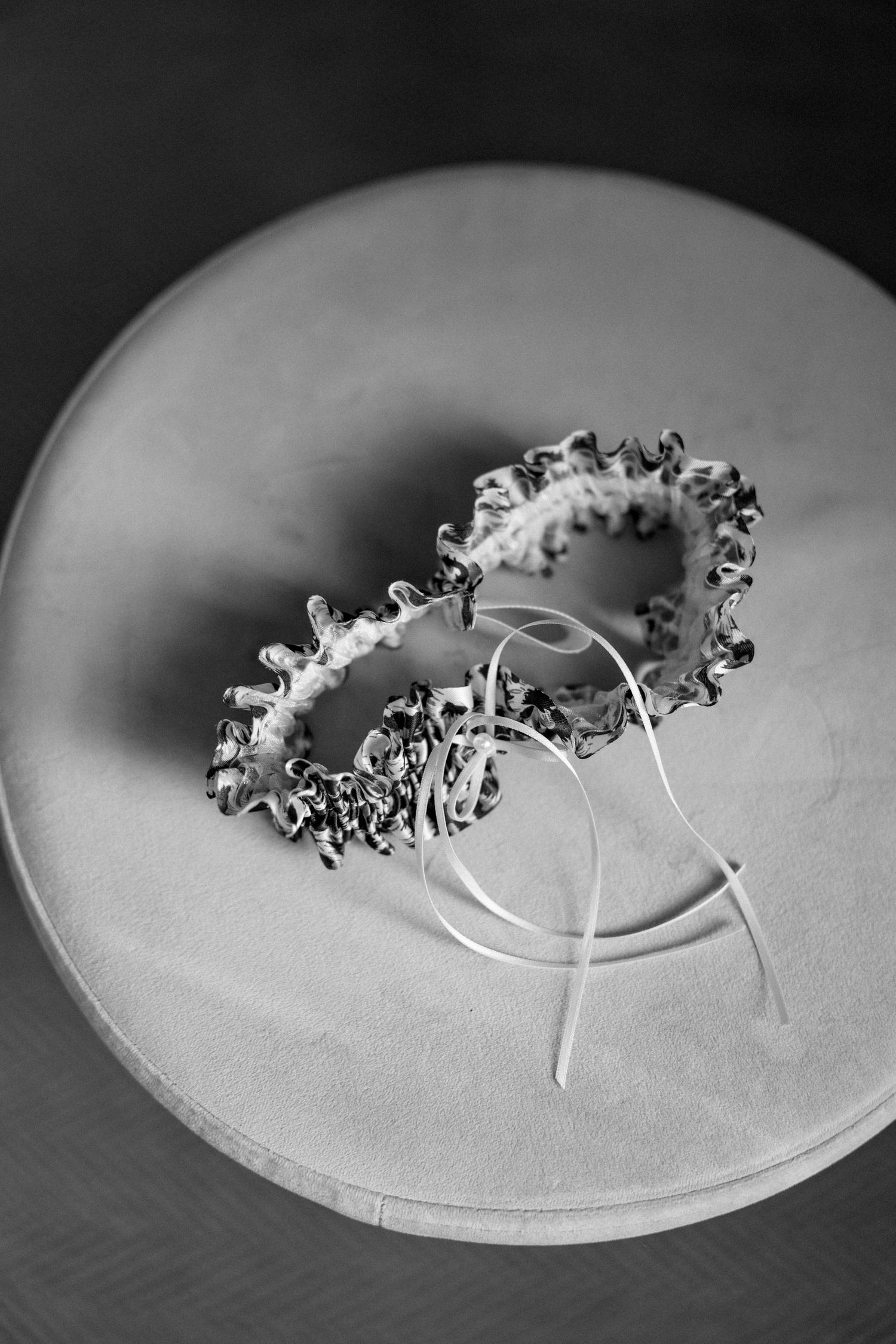 Delicate silver jewelry pieces arranged in a spiral pattern on a white surface.