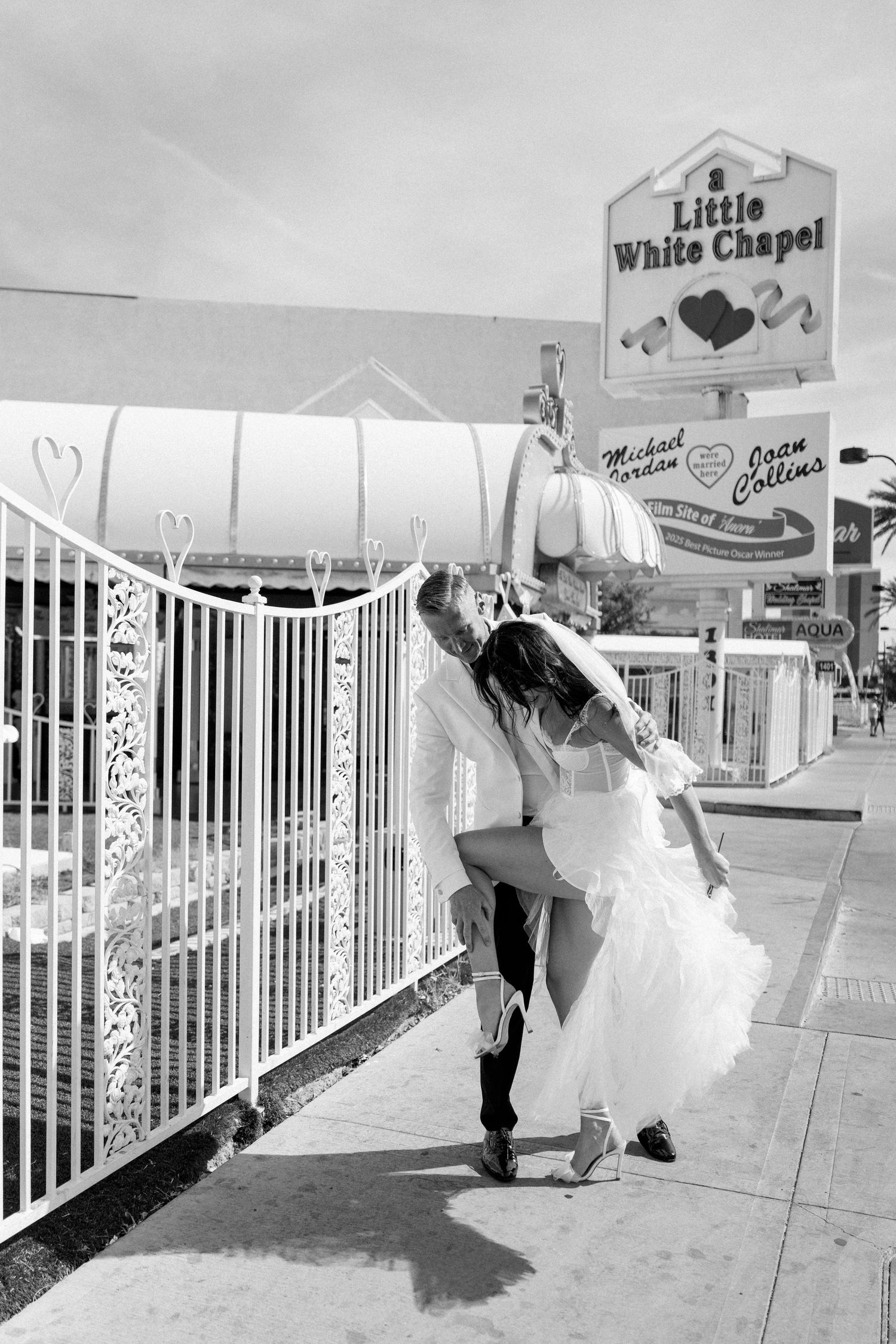 Wedding couple performs playful dance poses outside the Little White Wedding Chapel.