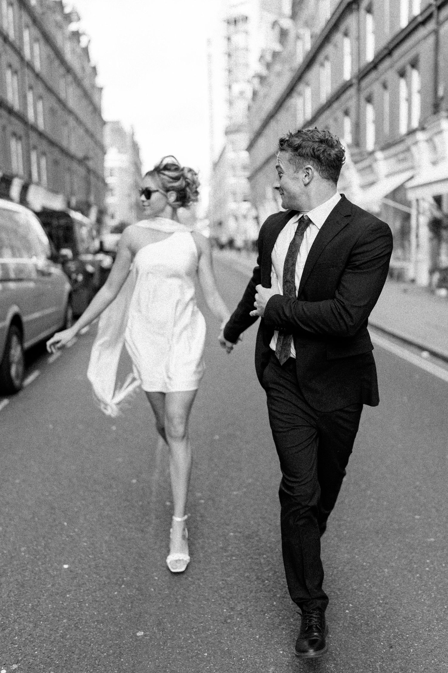 Dynamic black and white sequence of couple dancing on urban street.