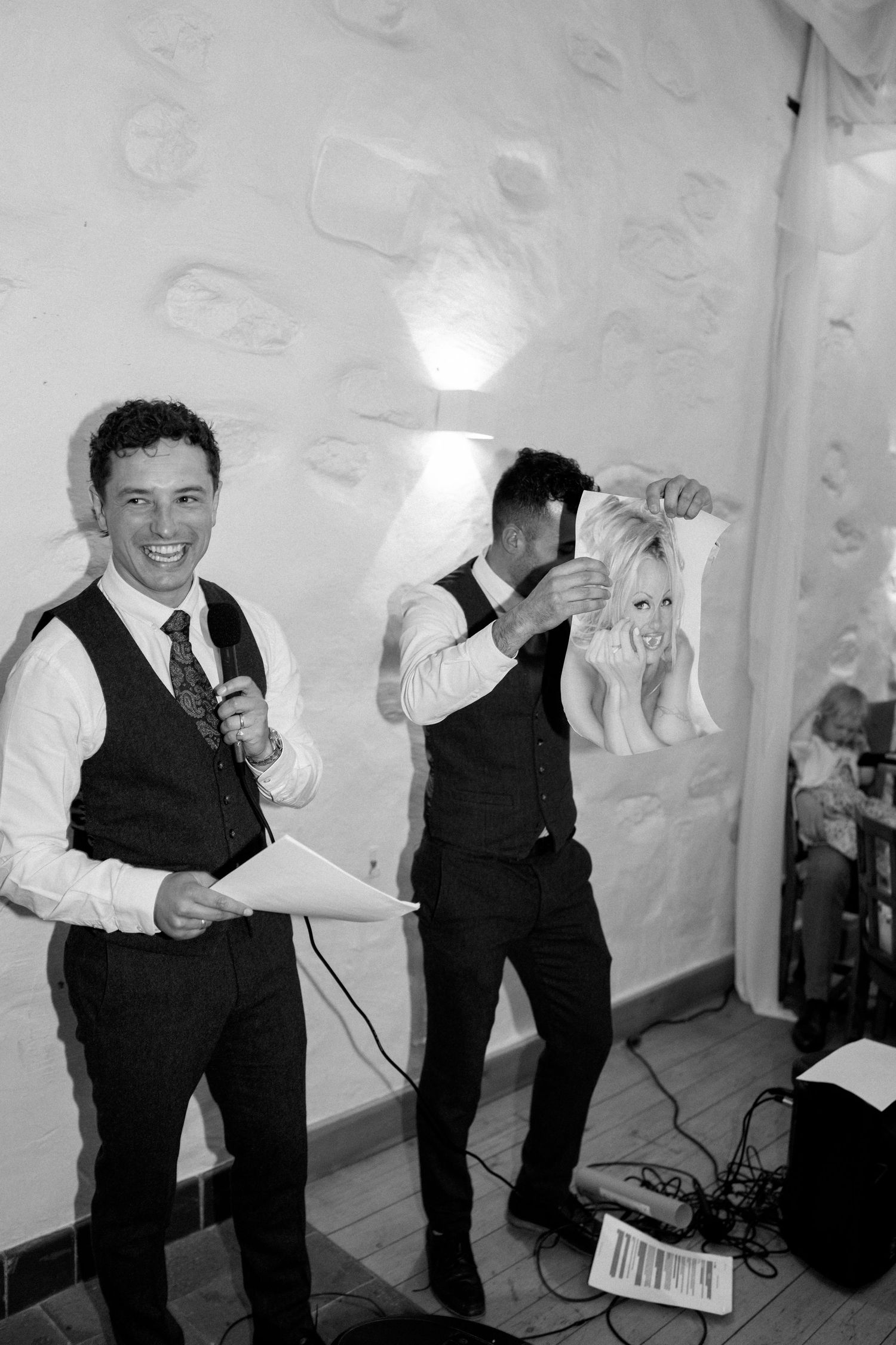 Black and white photo of performers in vests setting up equipment at an event.