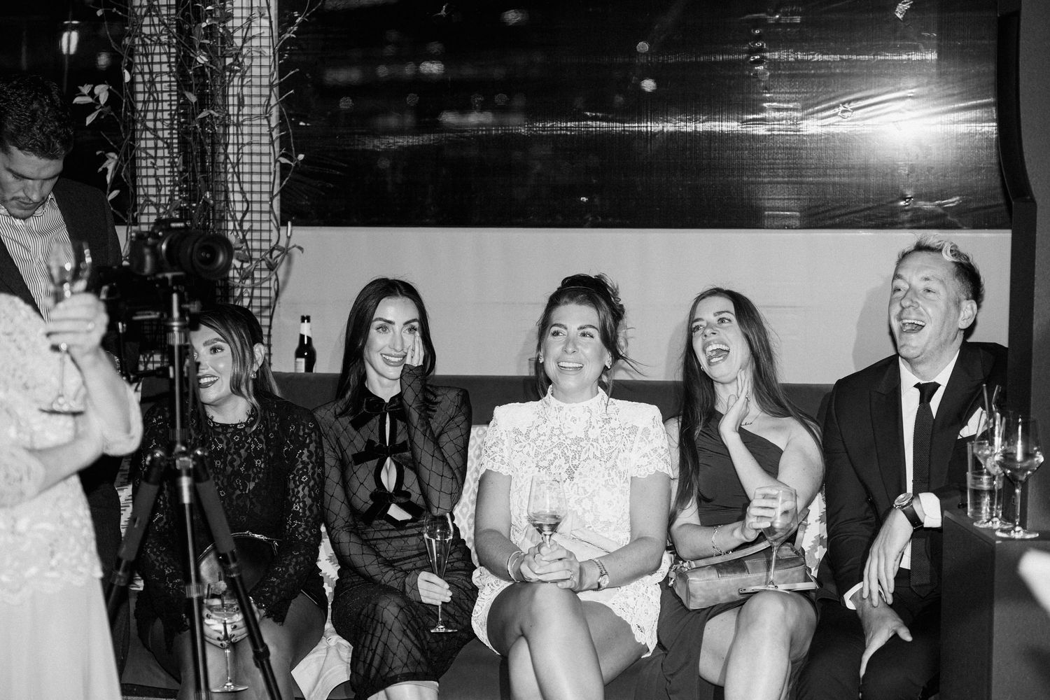 Wedding guests enjoying themselves at a dimly lit reception venue.