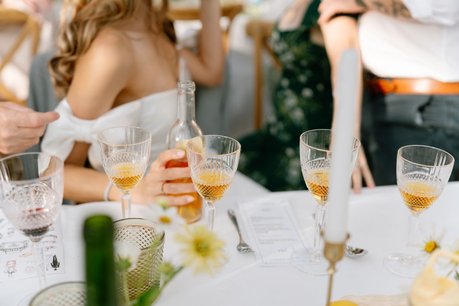 Wedding reception table with champagne glasses and elegant place settings in natural light.