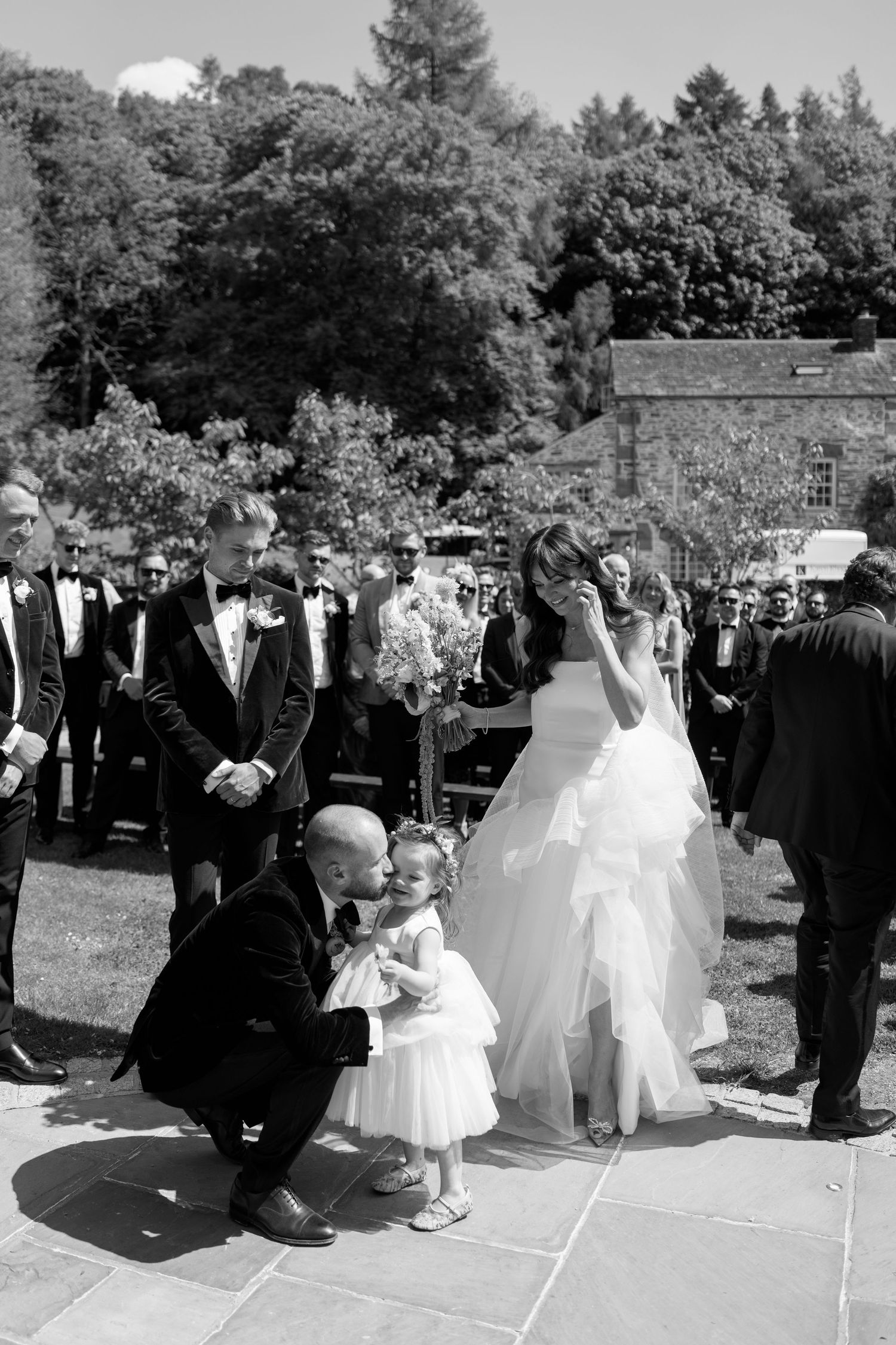 Black and white photo of wedding party gathering on stone patio.