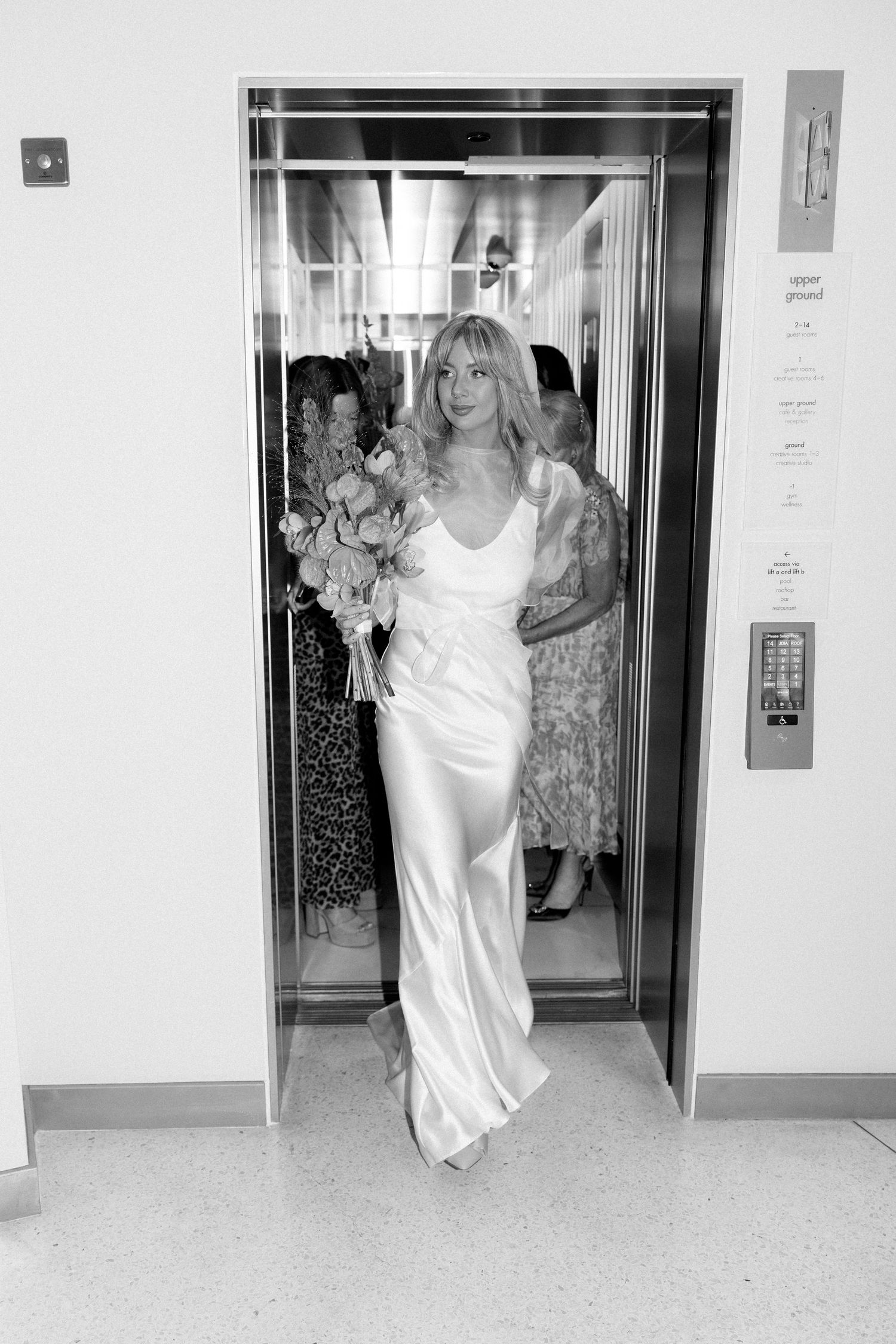 Black and white photos showing someone exiting an elevator in a flowing white dress.