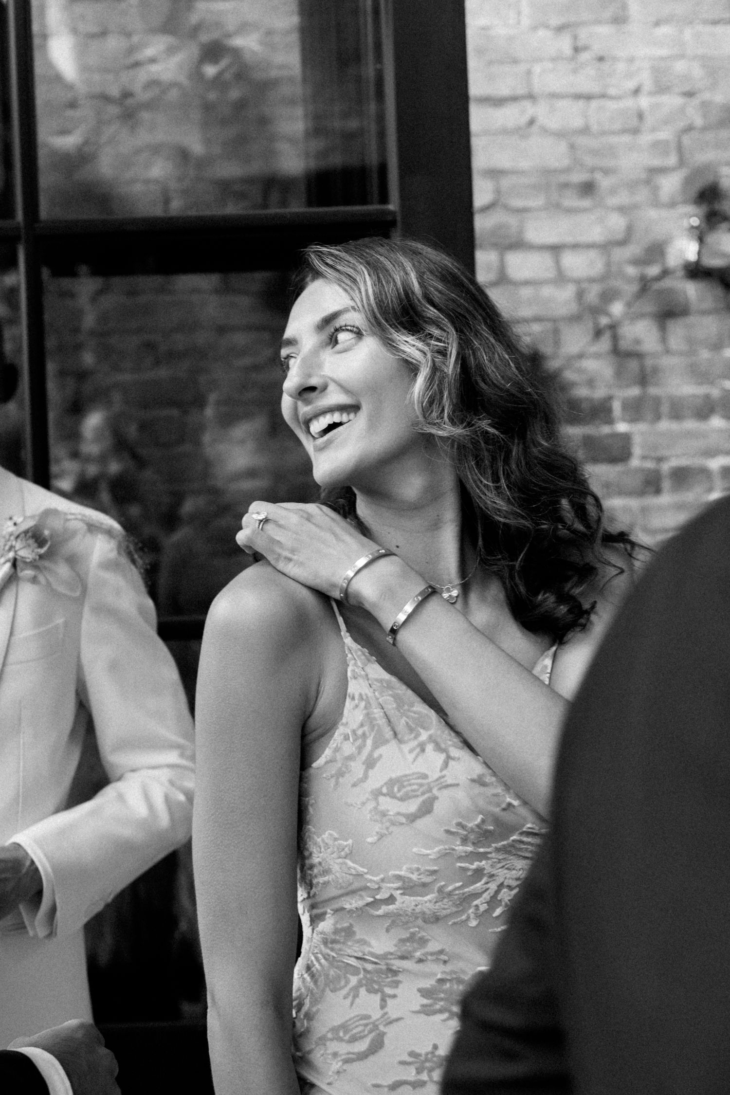 Candid black and white photo capturing laughter and joy at a celebration.