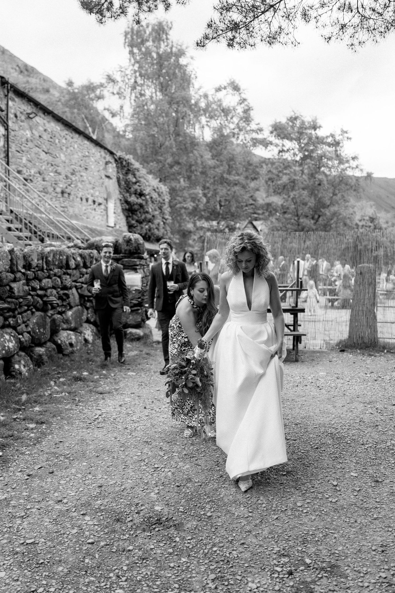 Black and white wedding photos showing movement across a garden pathway.