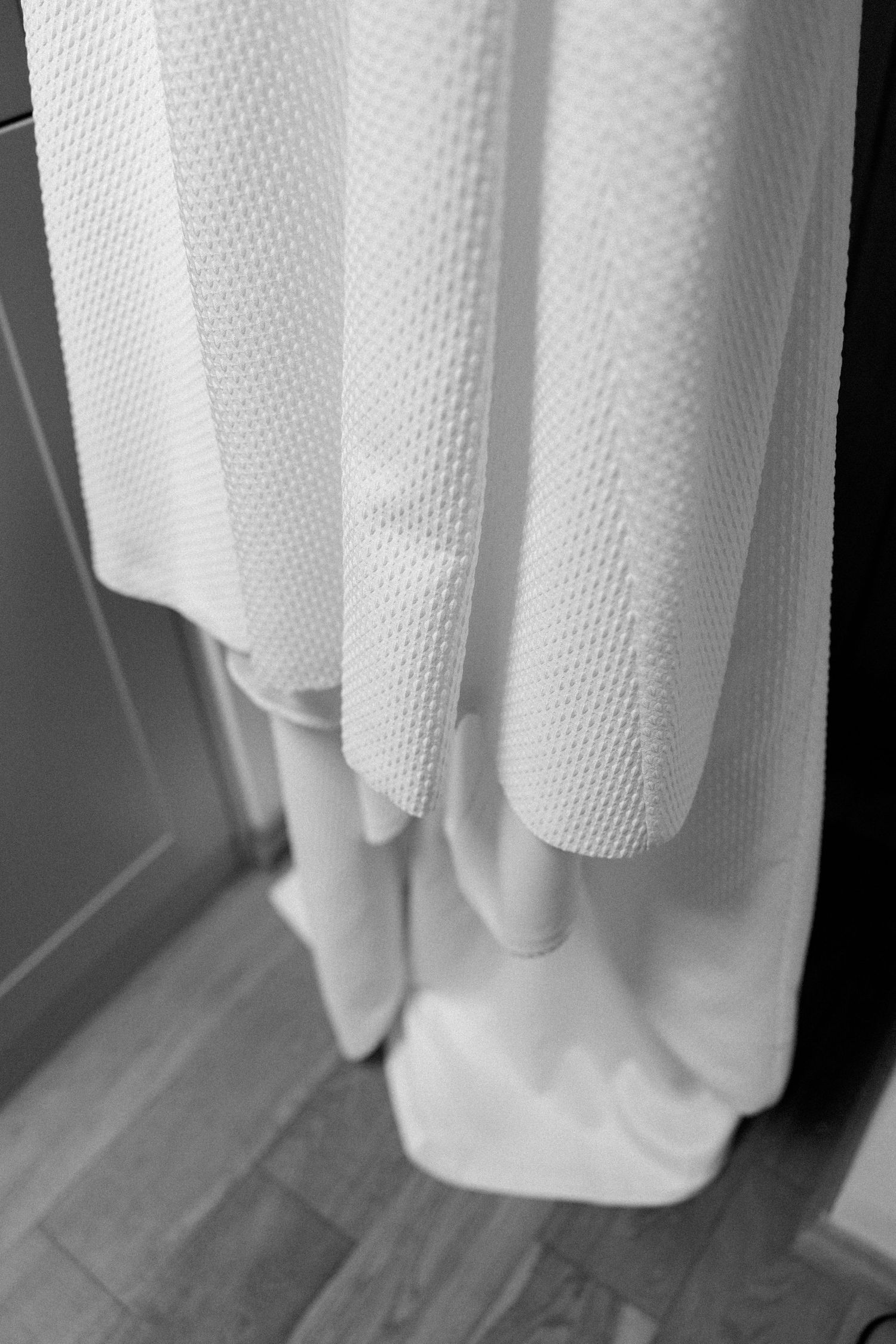 Close-up view of white curtains with textured fabric showing natural light and folds.