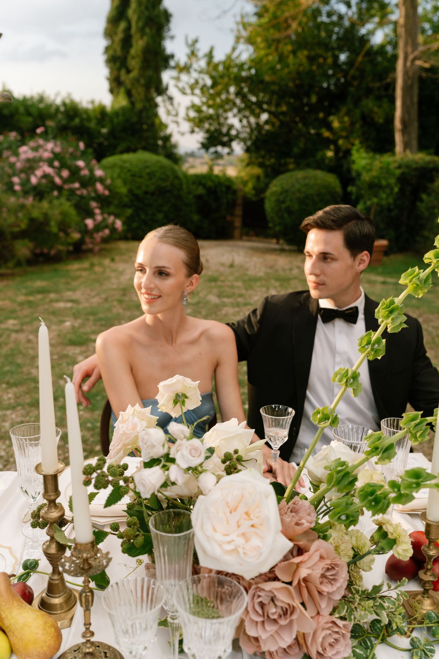 Elegant wedding table setting with white flowers, candles and fine crystal glassware.
