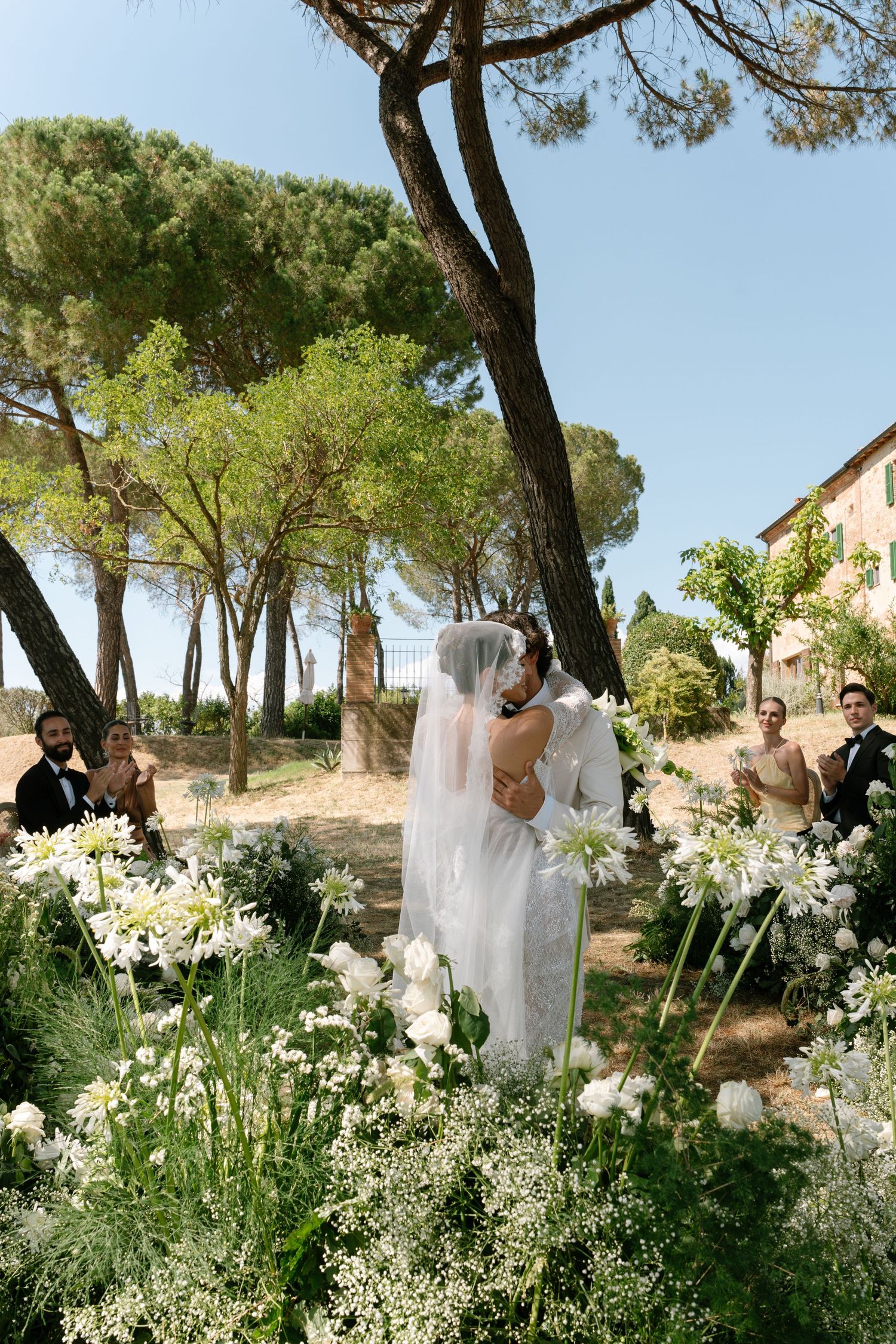 A wedding celebration in a beautiful Italian garden with white floral decorations.