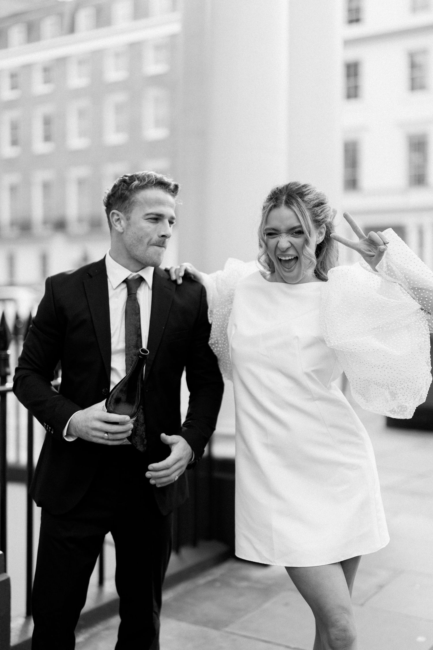 Candid black and white series showing laughter and celebration in an urban setting.