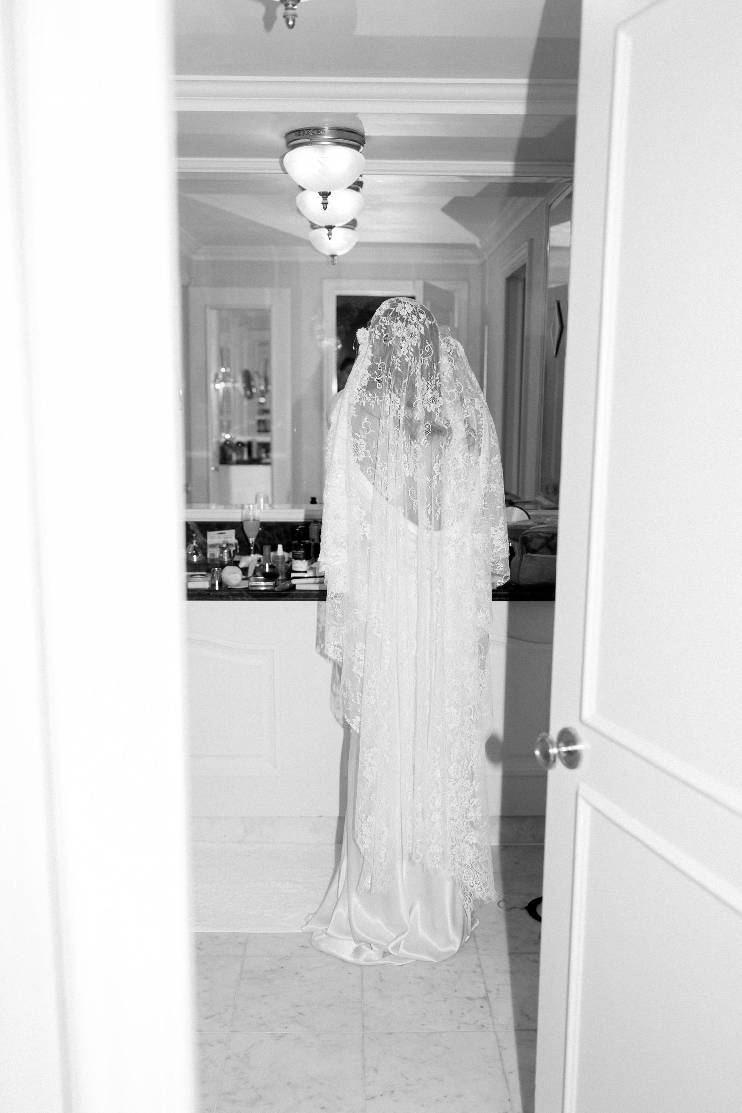 White wedding dress displayed on a hanger in an elegant hallway with classic interior details.