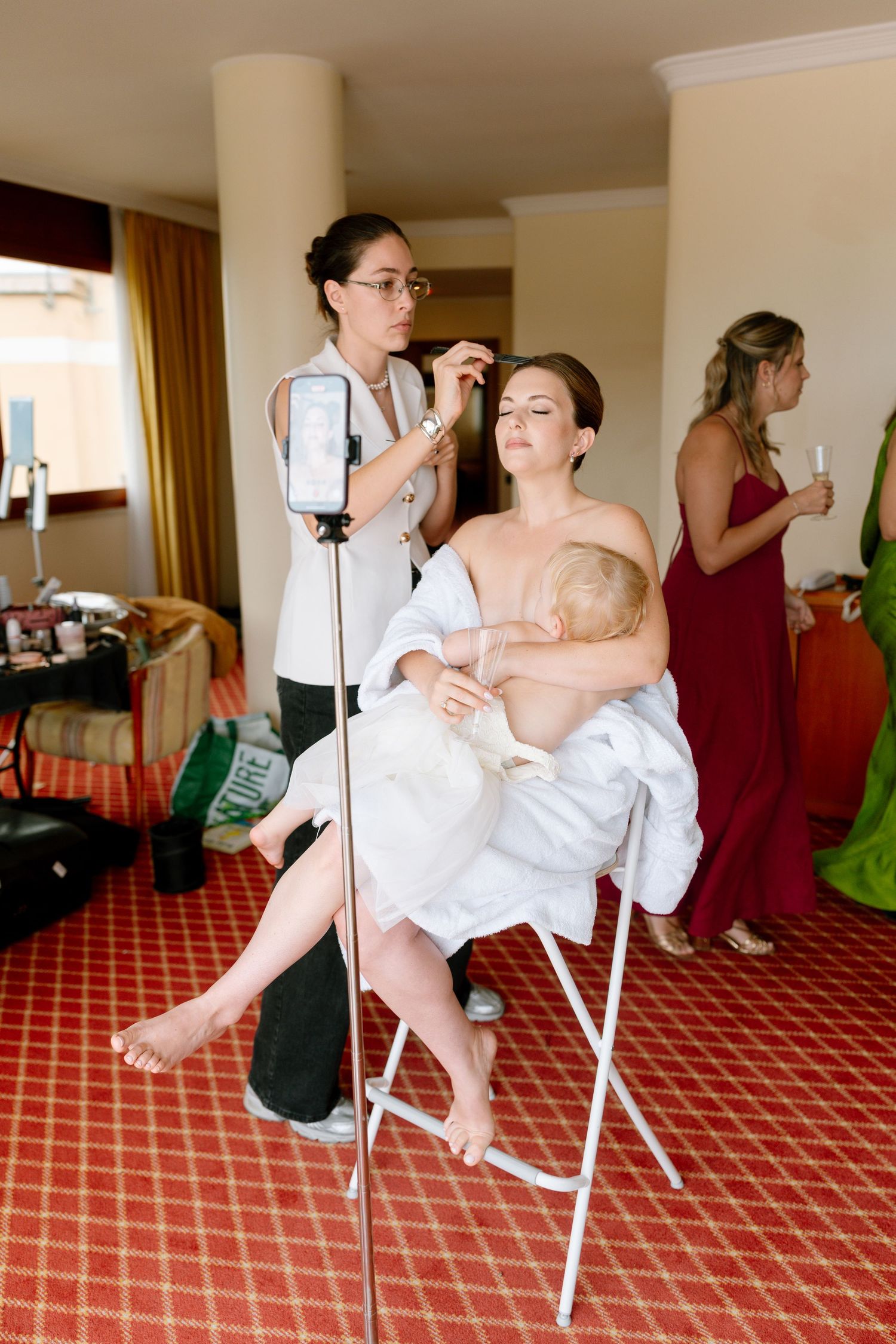 Wedding preparation scene showing styling activities in a room with geometric patterned carpet.