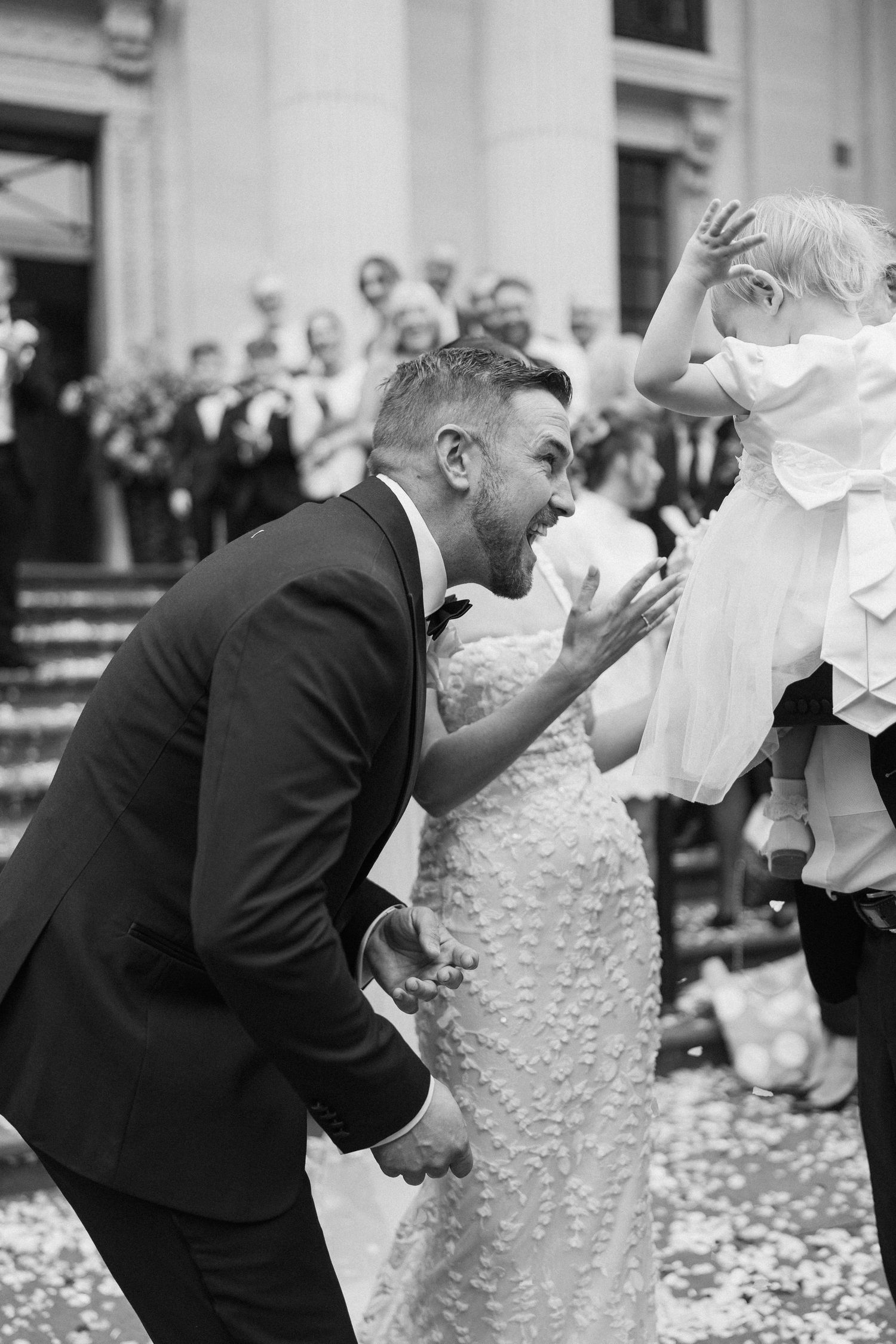 Black and white sequence showing a playful wedding dance dip on the steps of a grand building.