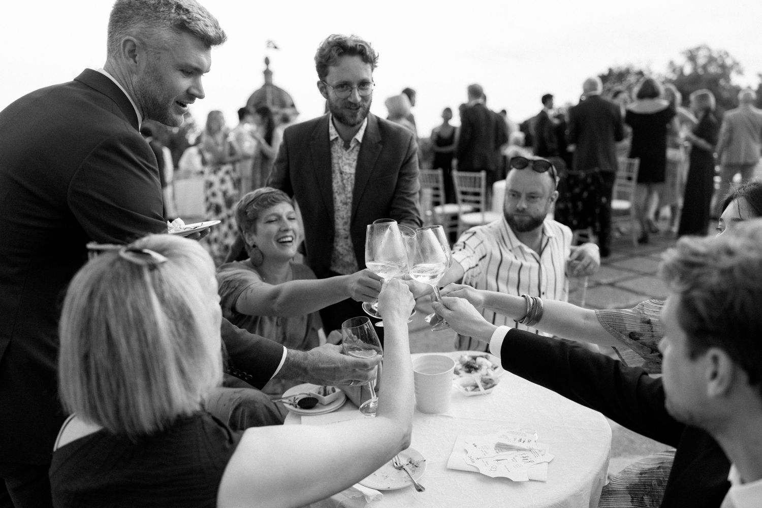 Guests enjoying drinks and conversation at an outdoor reception with mountain views.