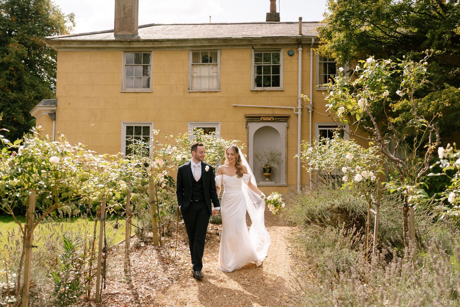 Elegant wedding photography sequence outside historic yellow building with landscaping.