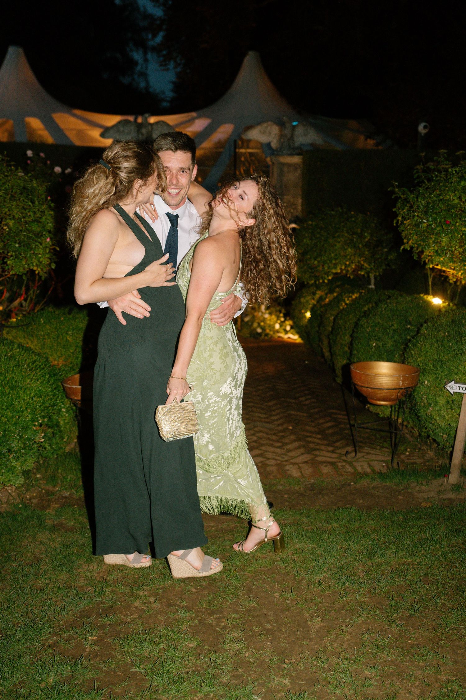 Party guests dancing and dipping on an outdoor patio at night.