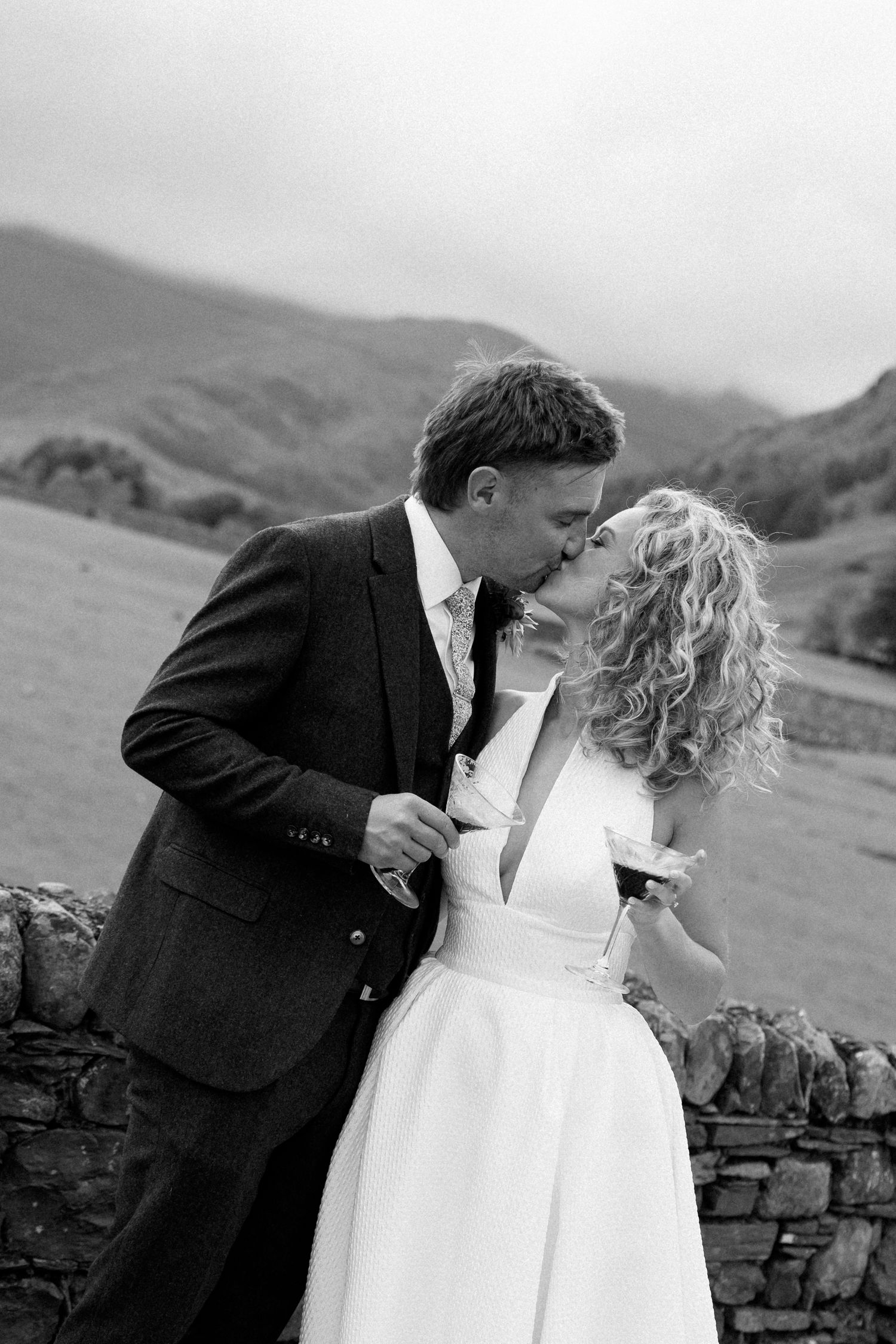 Intimate black and white wedding portrait captured against a scenic mountain landscape.